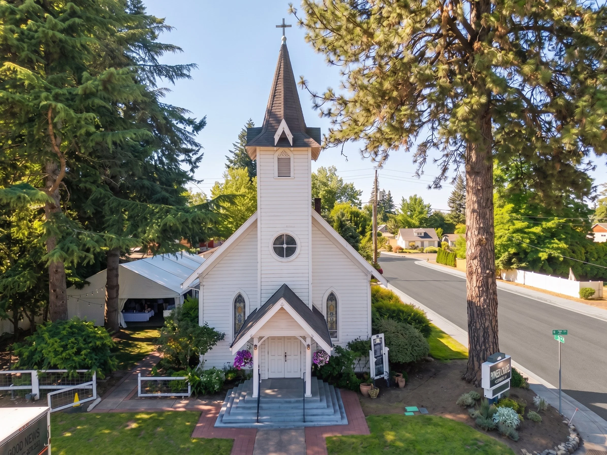 The white Canby Pioneer Chapel, surrounded by tall trees