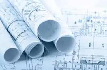 Wicked Maple Design - Several rolled blueprints on top of an architectural blueprint plan.