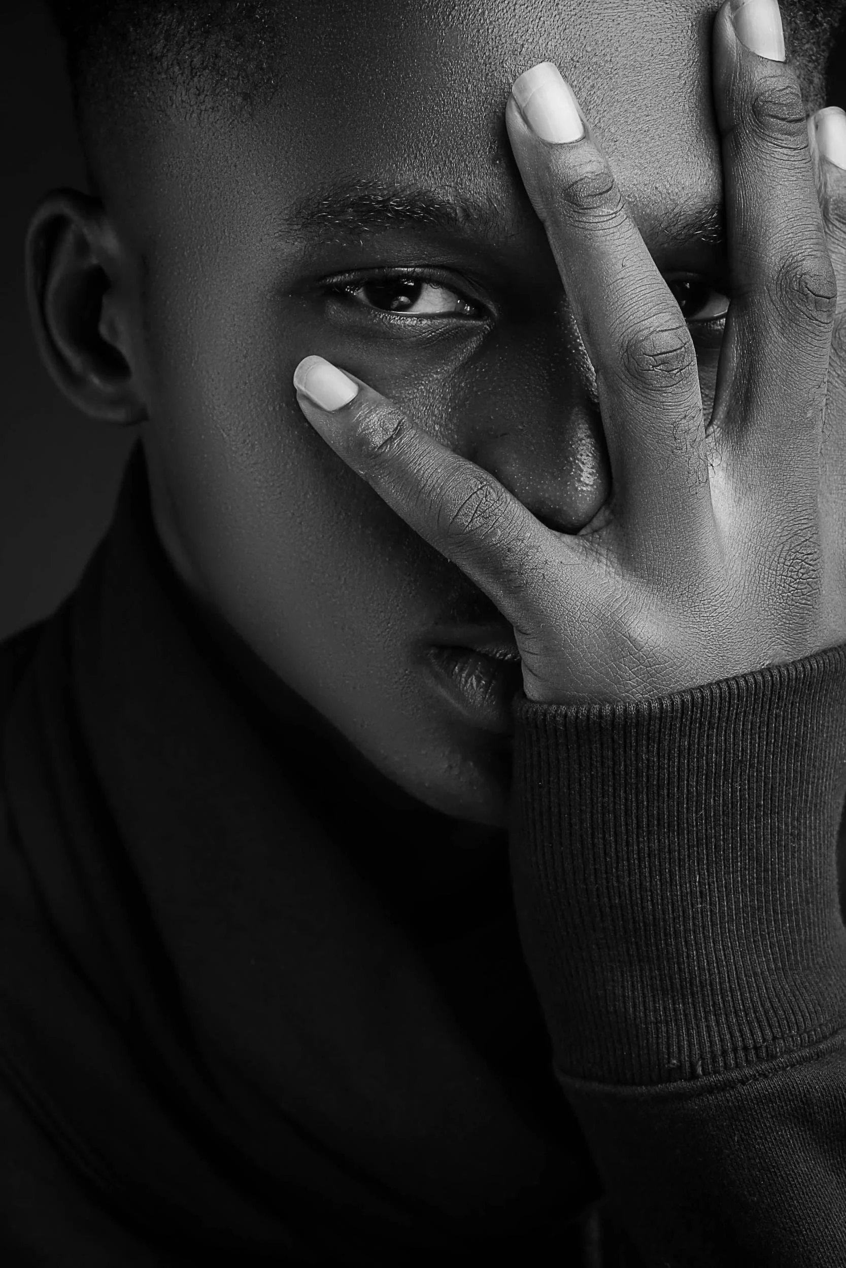 Close-up of a man covering part of his face with his hand, representing how EMDR therapy helps process trauma
