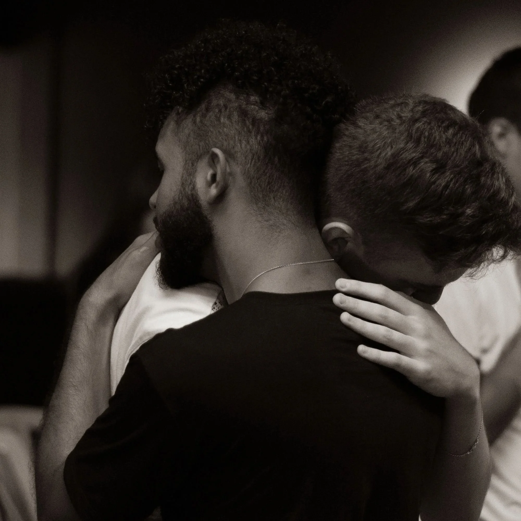 Two men sharing a close embrace, representing connection in couples therapy