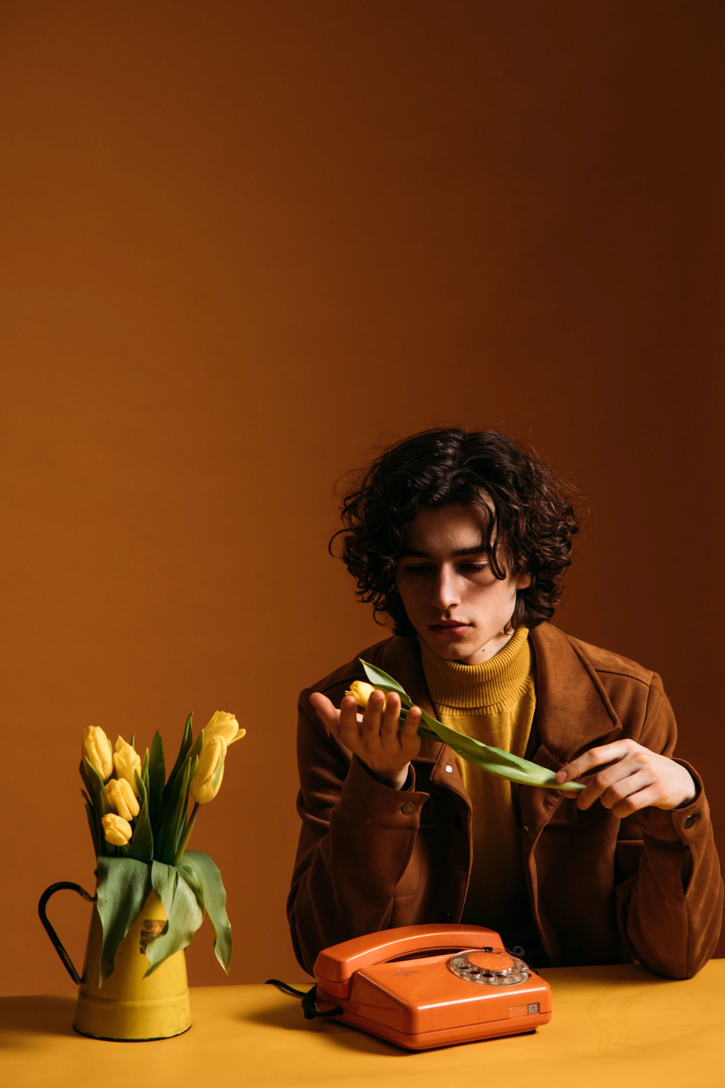 Young man holding yellow tulips in warm light, reflecting on what to expect in individual therapy