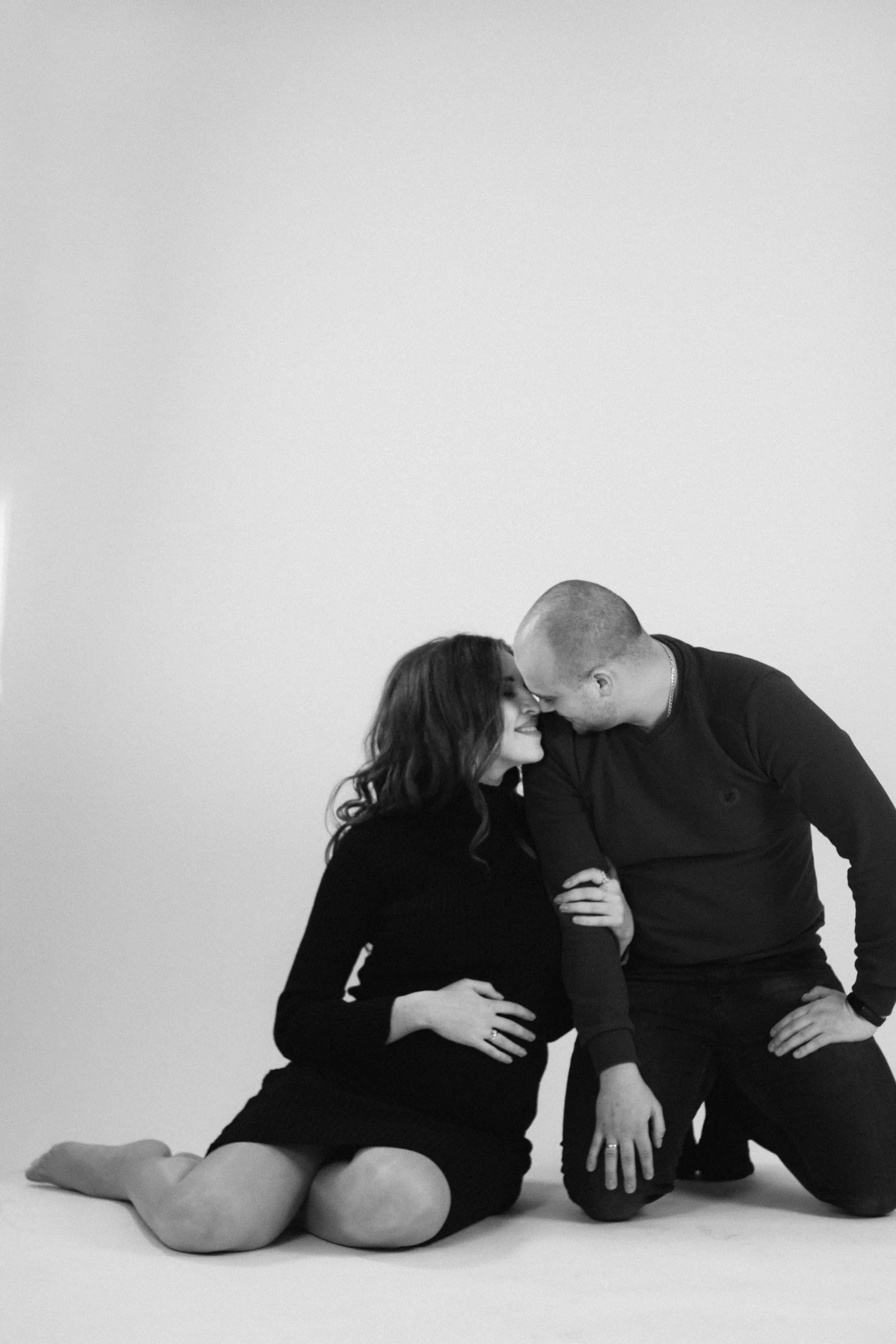 Couple sitting close on the floor with foreheads touching, representing who couples therapy is for