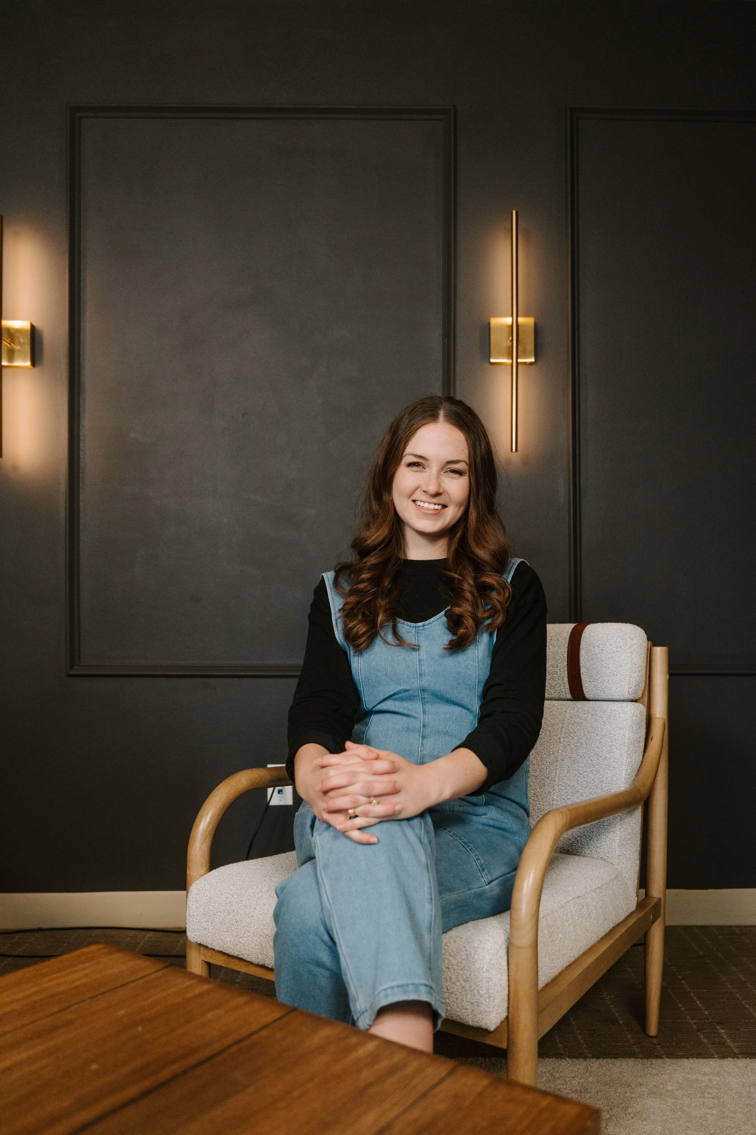 Caroline Bosley, founder and head coach of The Vocal Society, seated in a studio chair
