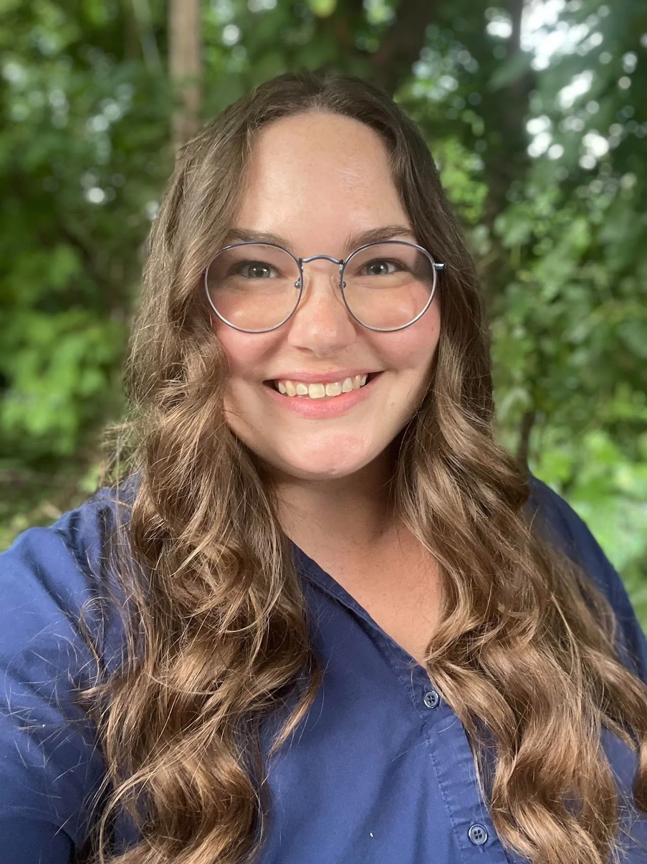 Virtual therapist Rachel Sims, LPC with nature and trees behind her.