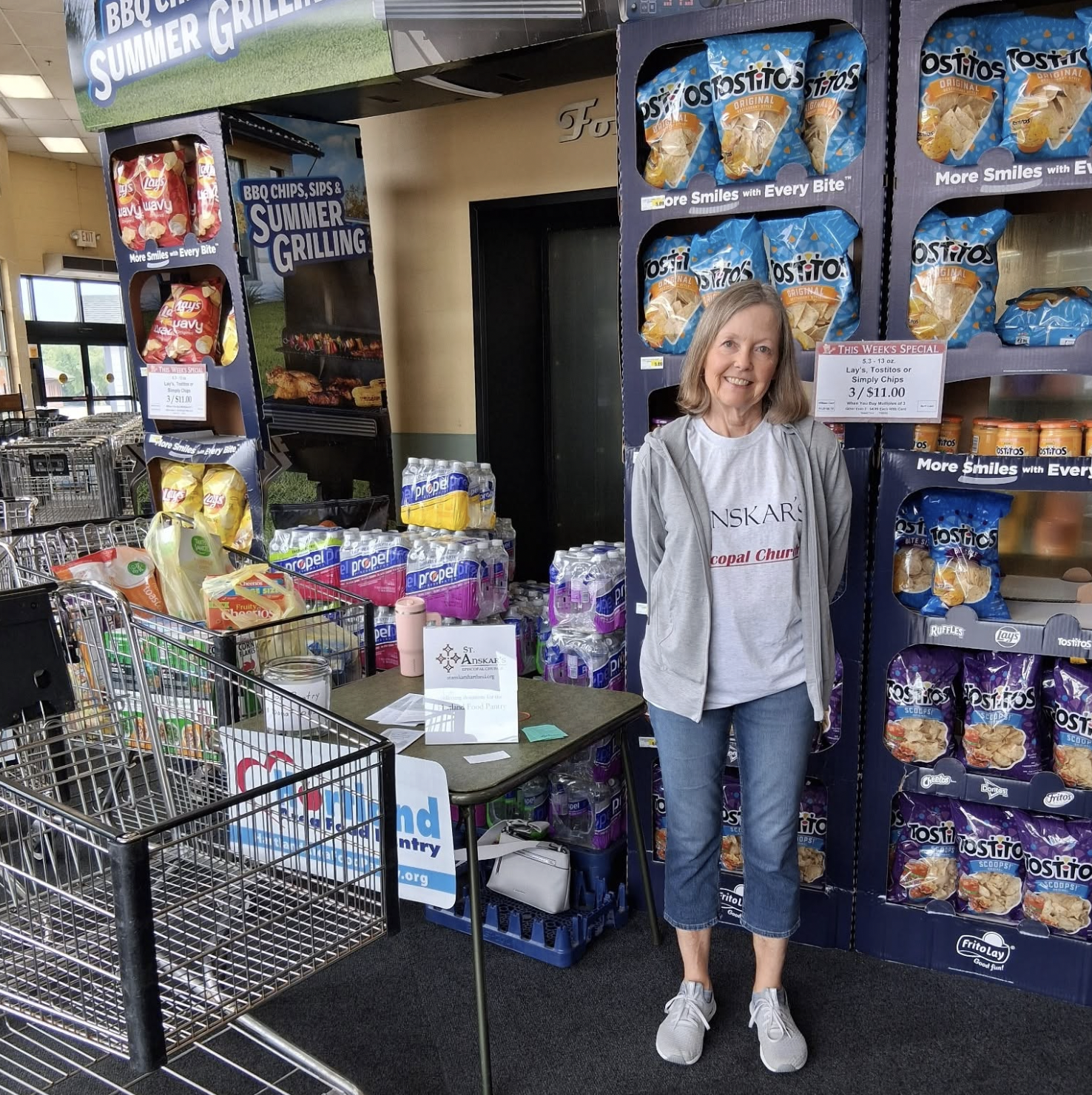 A St. Anskar's Episcopal Church parishioner volunteers at a community food drive in Hartland, Wisconsin, collecting donated food.