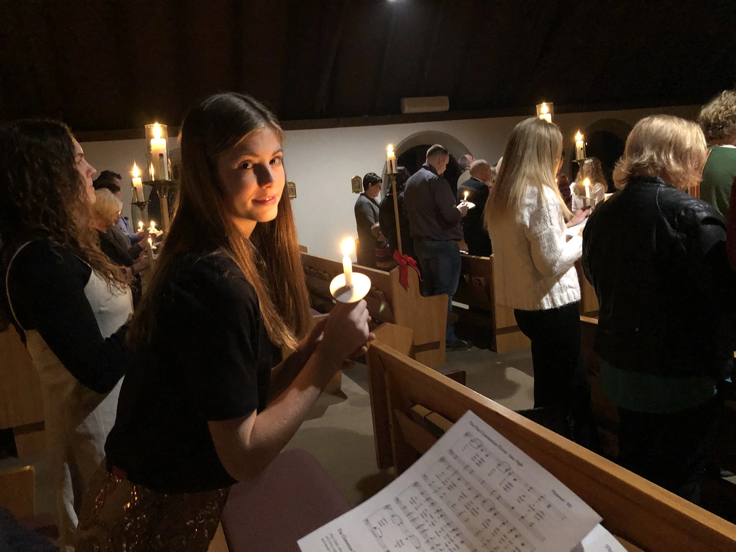 Parishioners hold candles while singing ‘Silent Night’ during the Christmas Eve Eucharist at St. Anskar’s Episcopal Church.