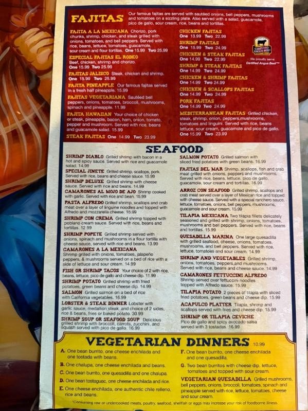 A restaurant menu page highlighting various fajitas and seafood dishes, with vegetarian dinner options at the bottom.