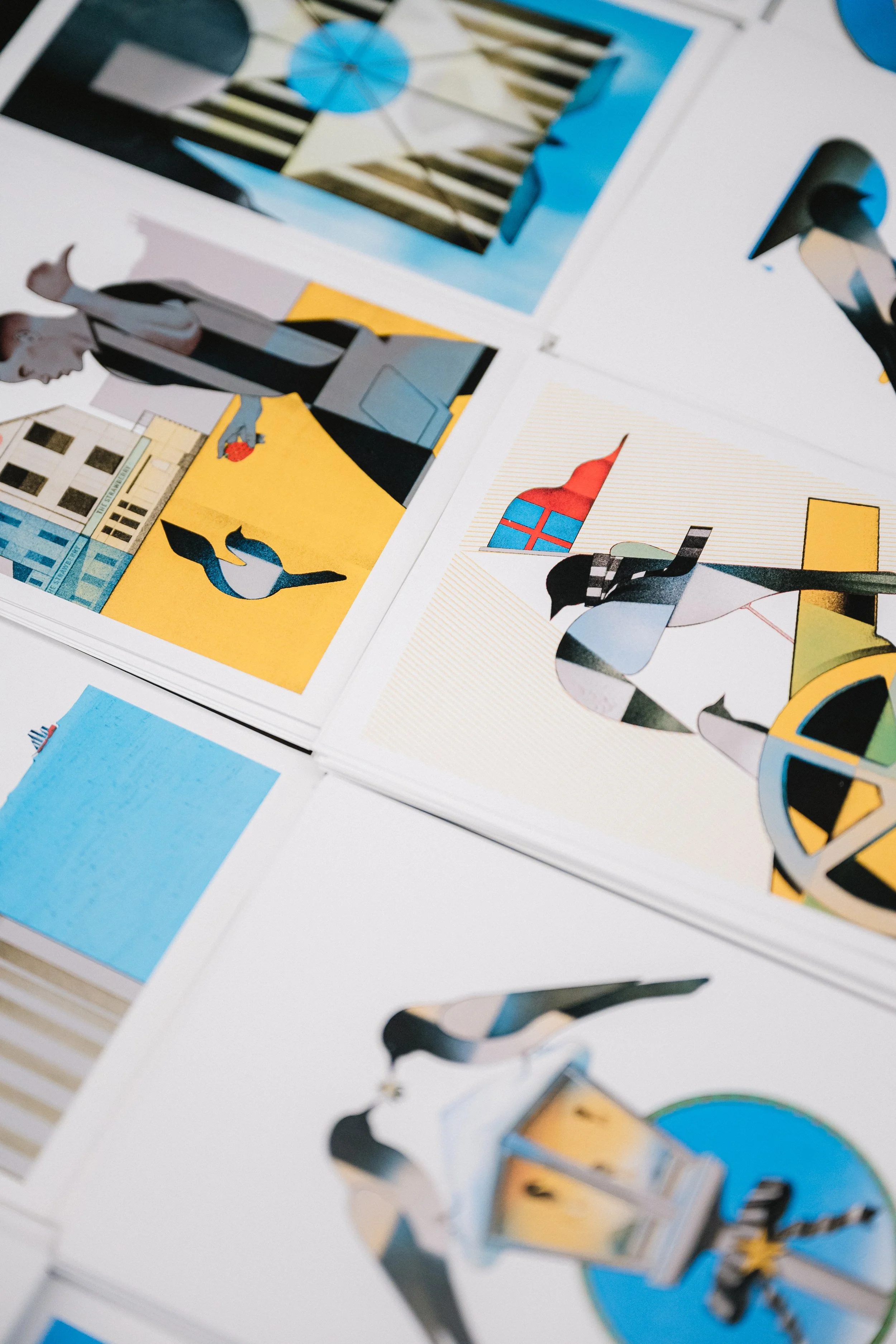 Colorful paper cutouts of various objects, including a person, a building, and a bottle, arranged on a white surface.