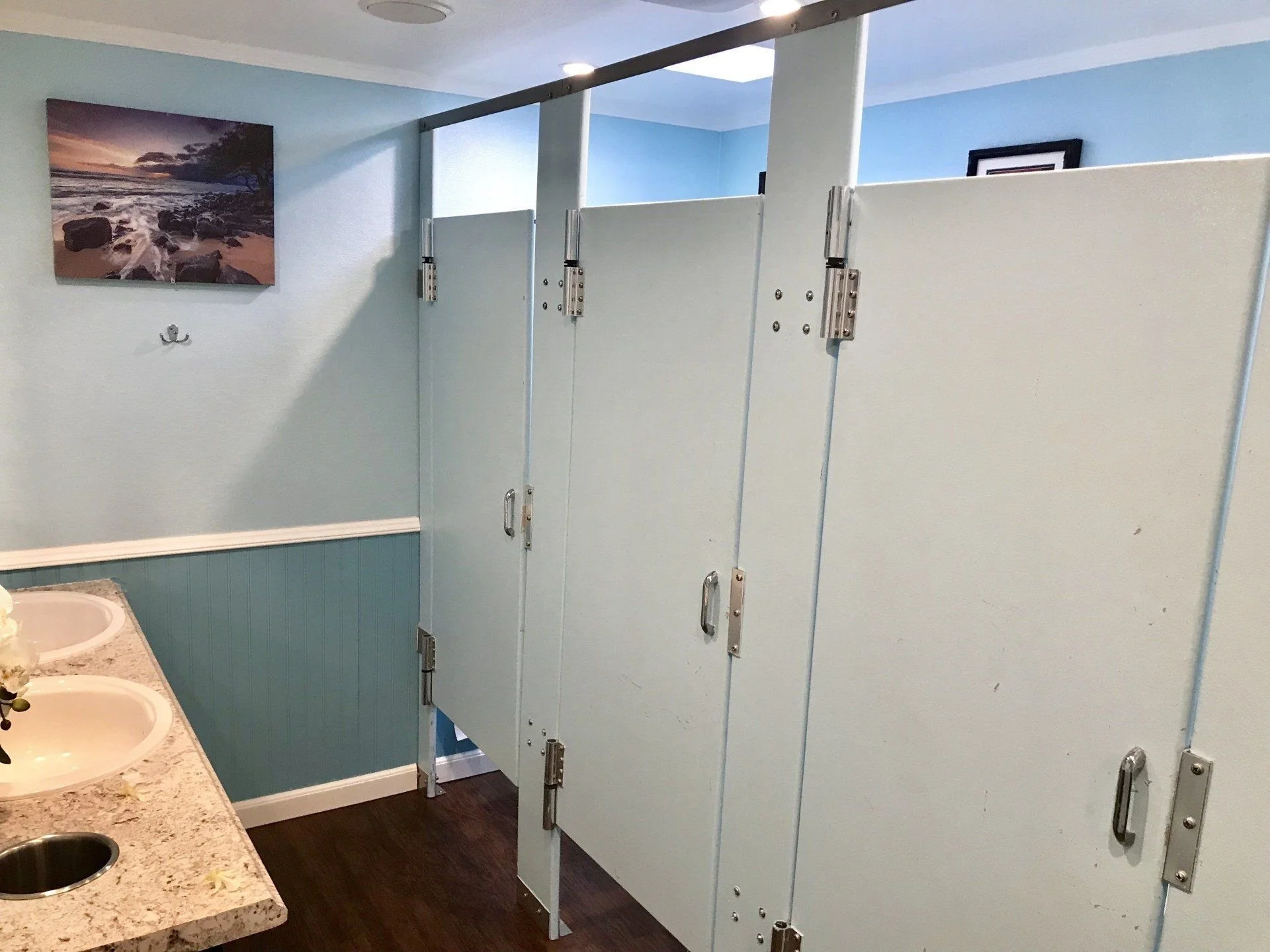 Toilet stalls and vanity in an event restroom trailer suite.