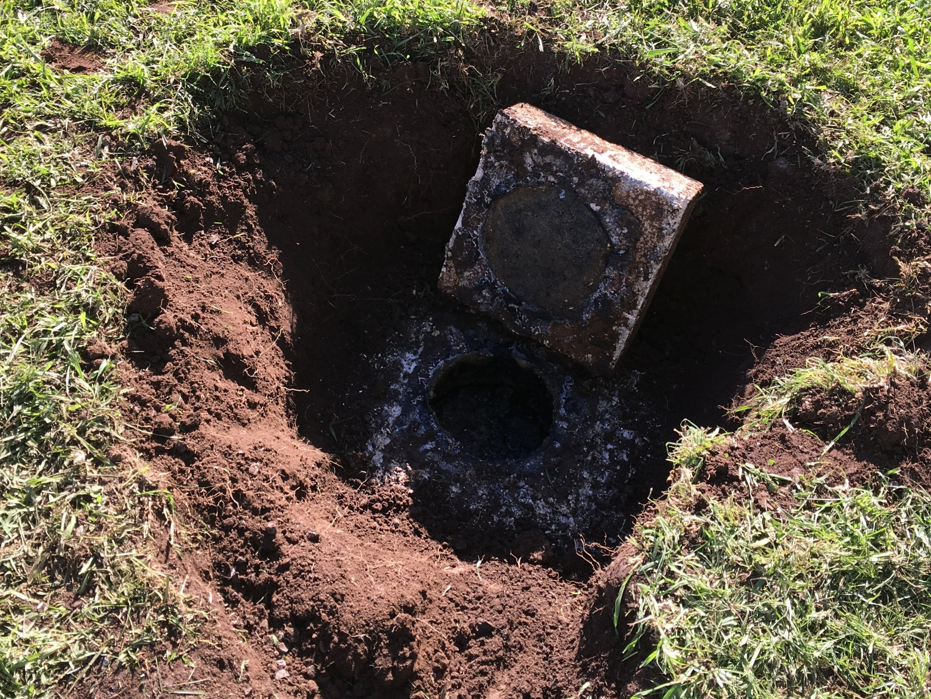 Exposed cesspool access opening.