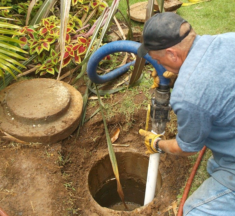 Septic tank pumping through an exposed access port.