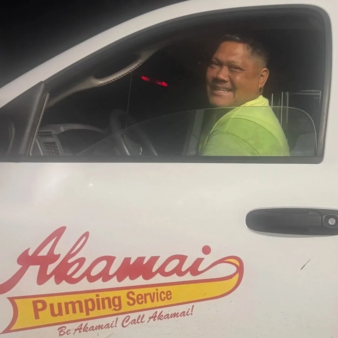Akamai driver smiling from the cab of a service truck.
