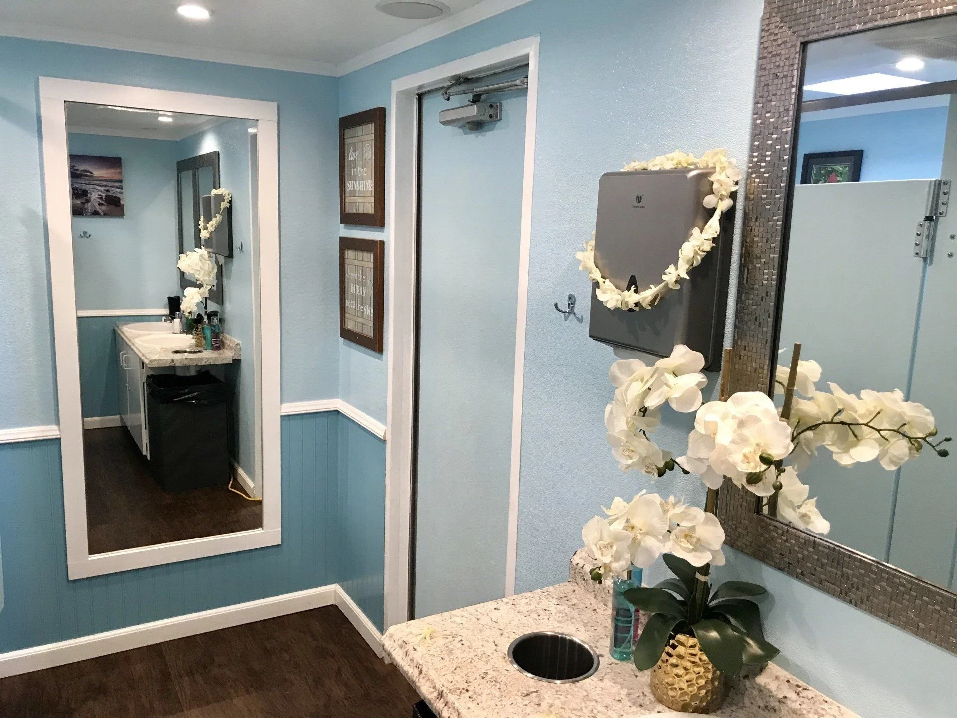 Vanity counter, mirror and sink inside an event restroom trailer.