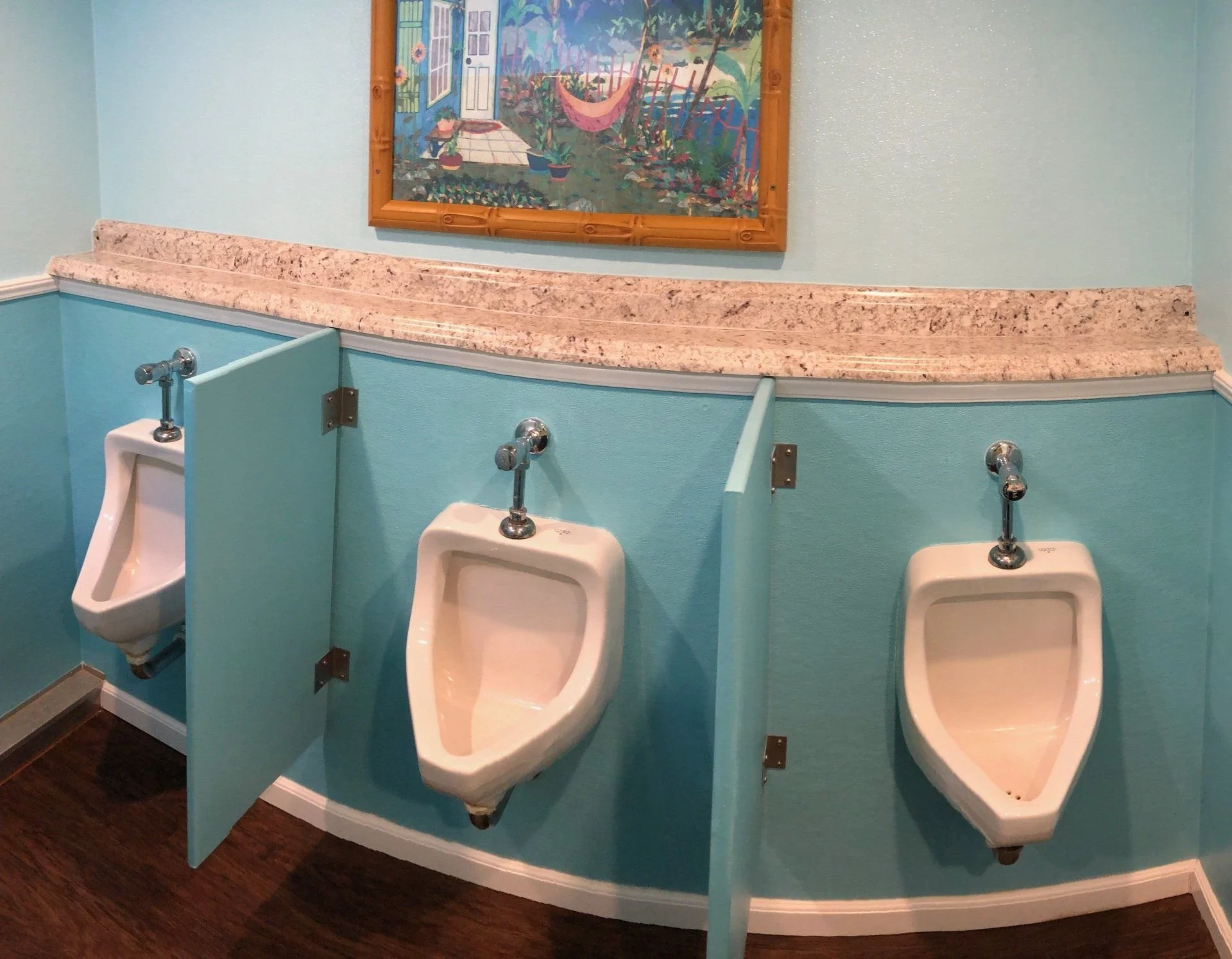 Urinal stations with partitions inside an event restroom trailer.