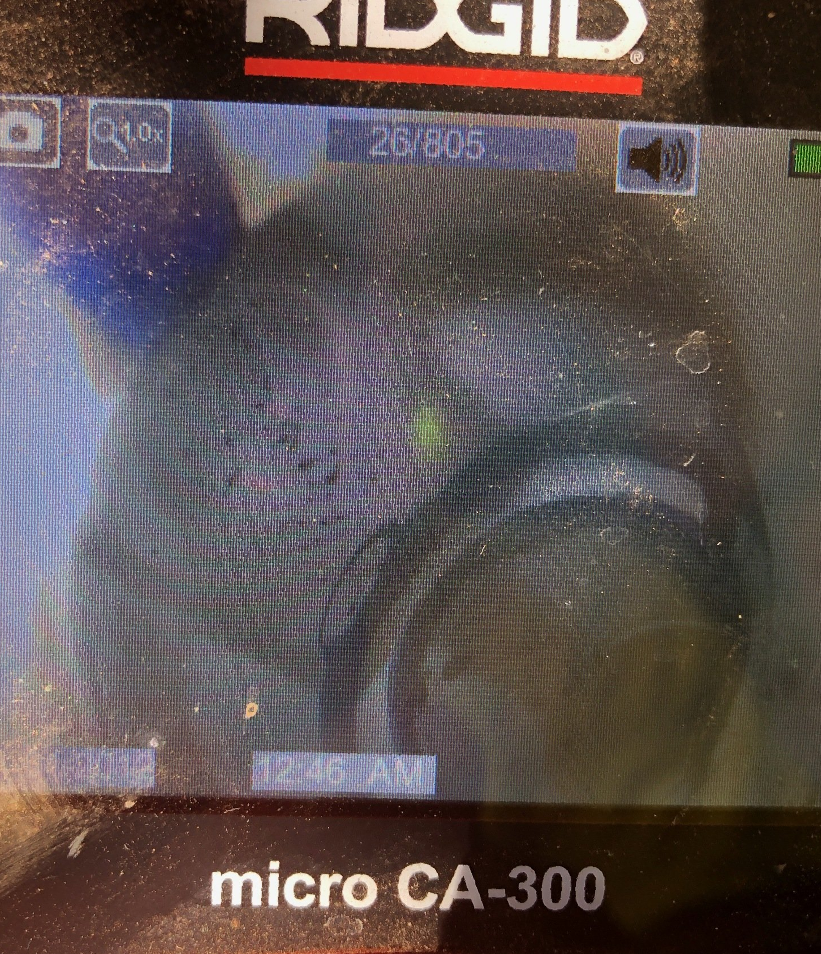 Plumbing camera monitor displaying an image from inside a pipe.