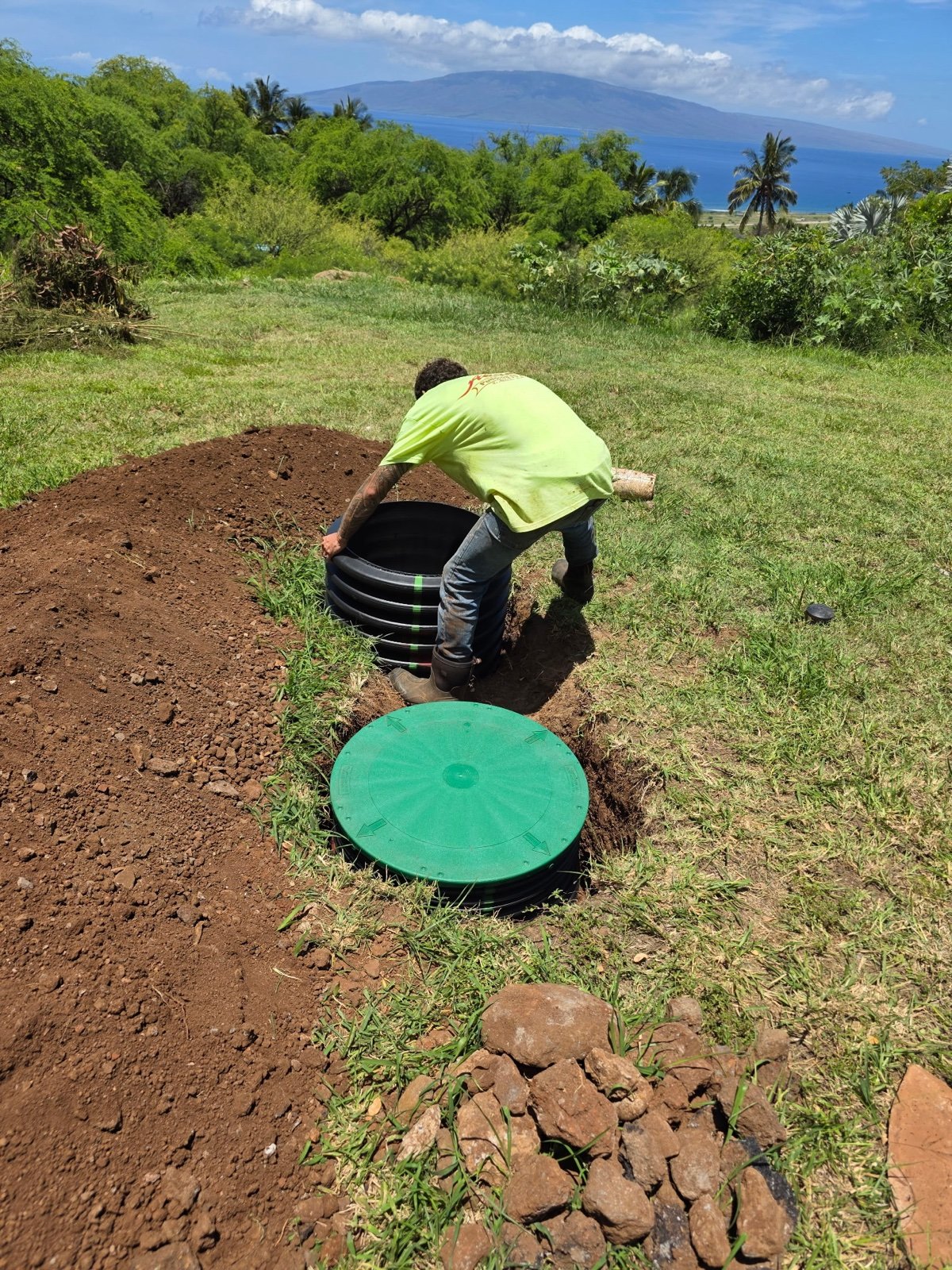 Akamai crew member installing a septic riser outdoors.
