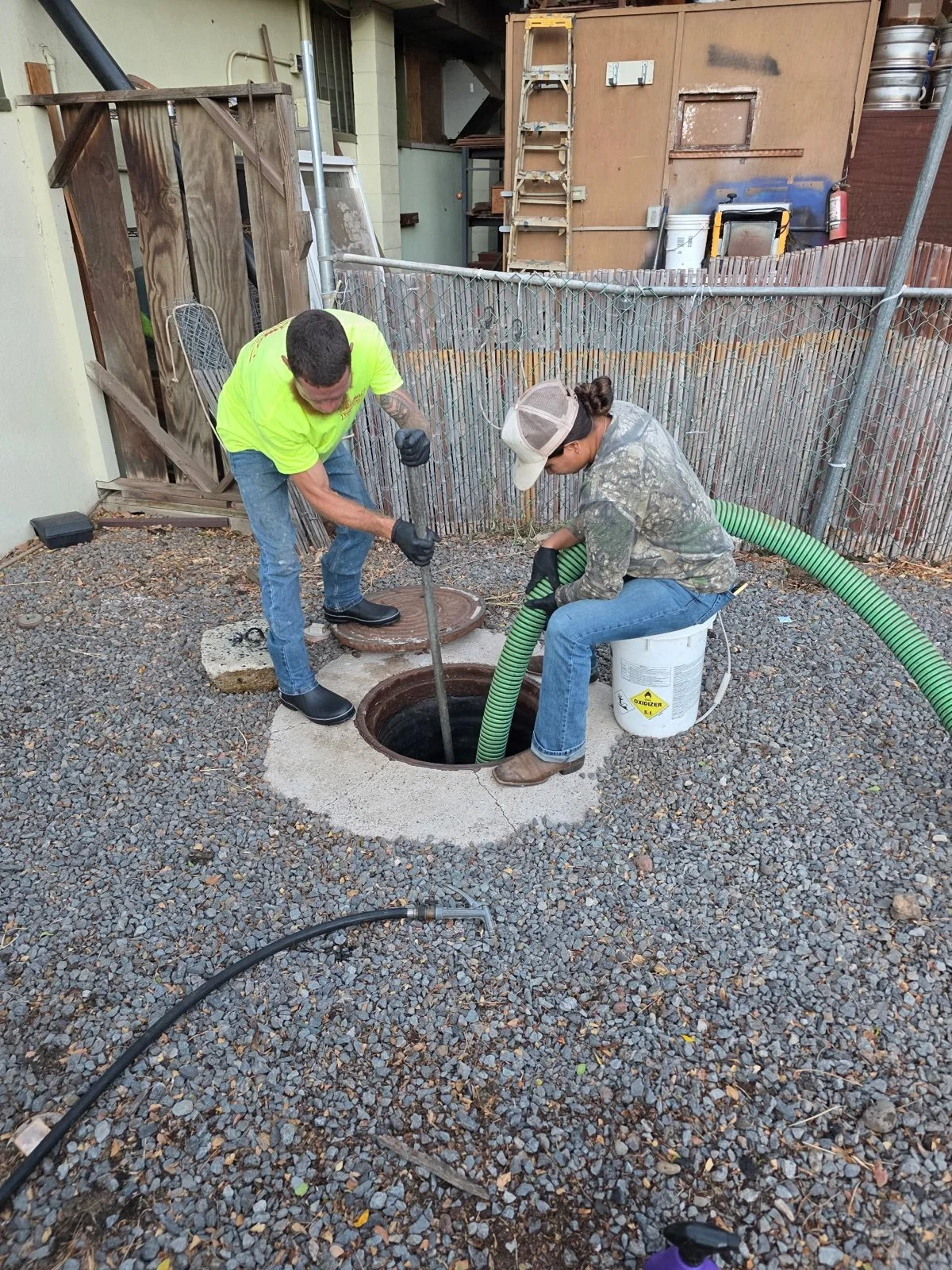 Two Akamai crew members servicing an access opening.