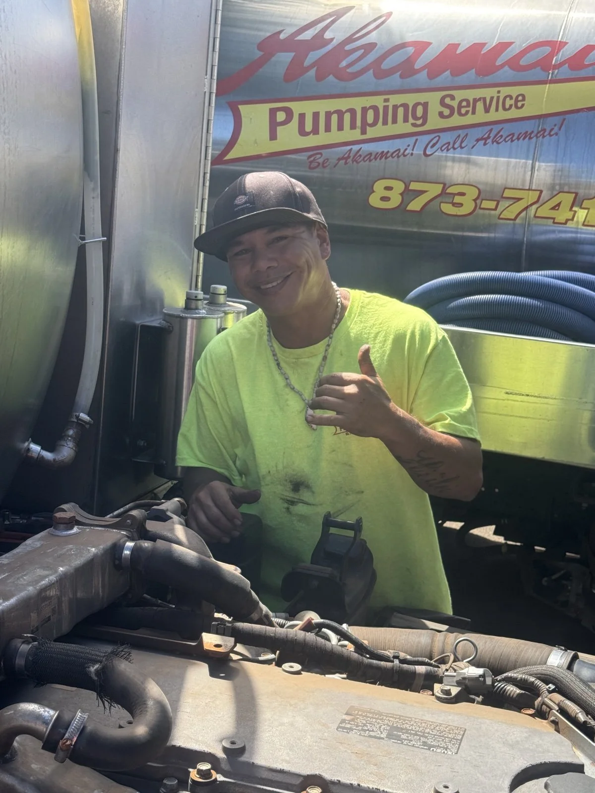 Akamai crew member working beside a truck engine.