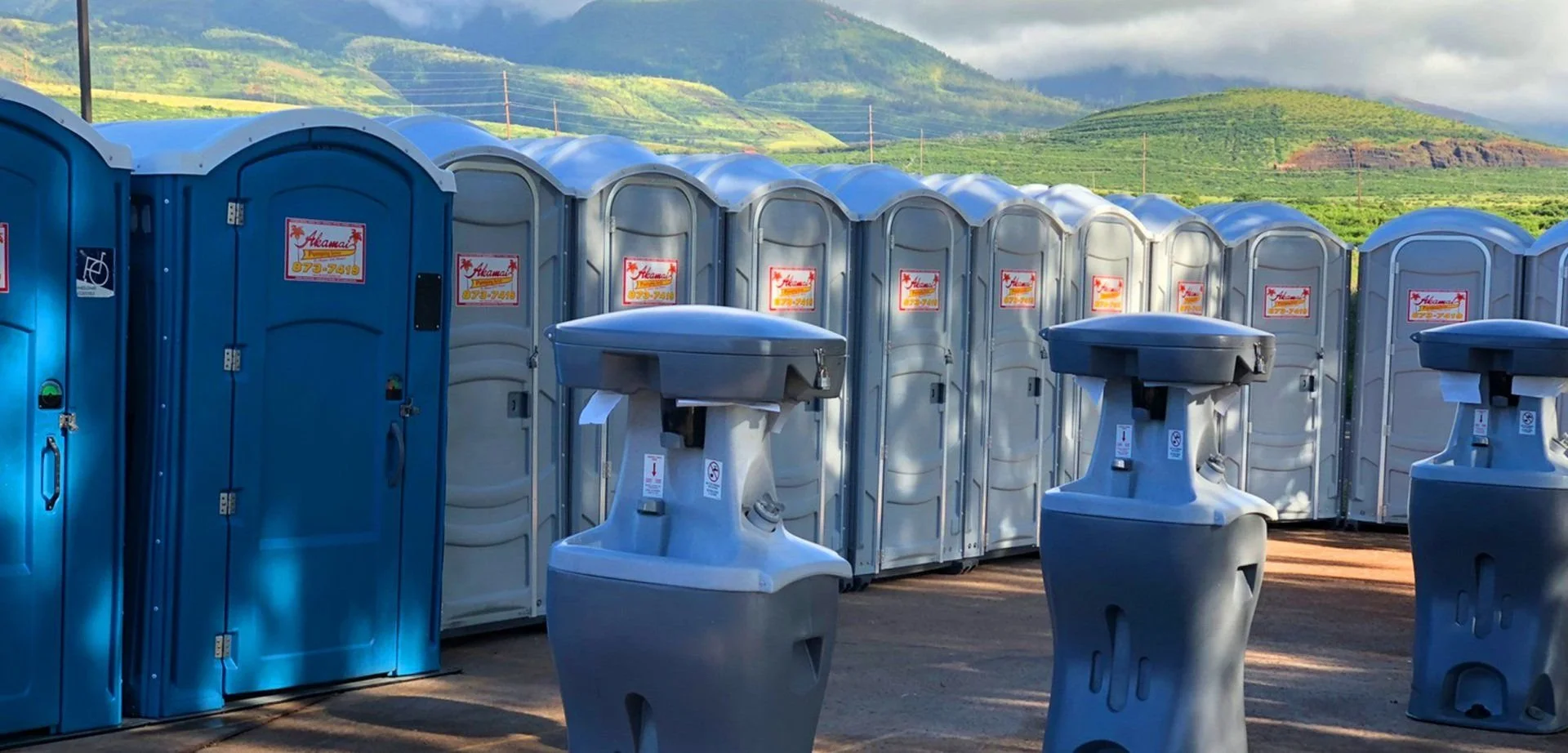 Portable toilets and handwash stations arranged at a service site.