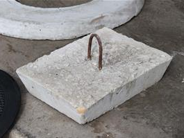 Square concrete access plug with a lifting handle.