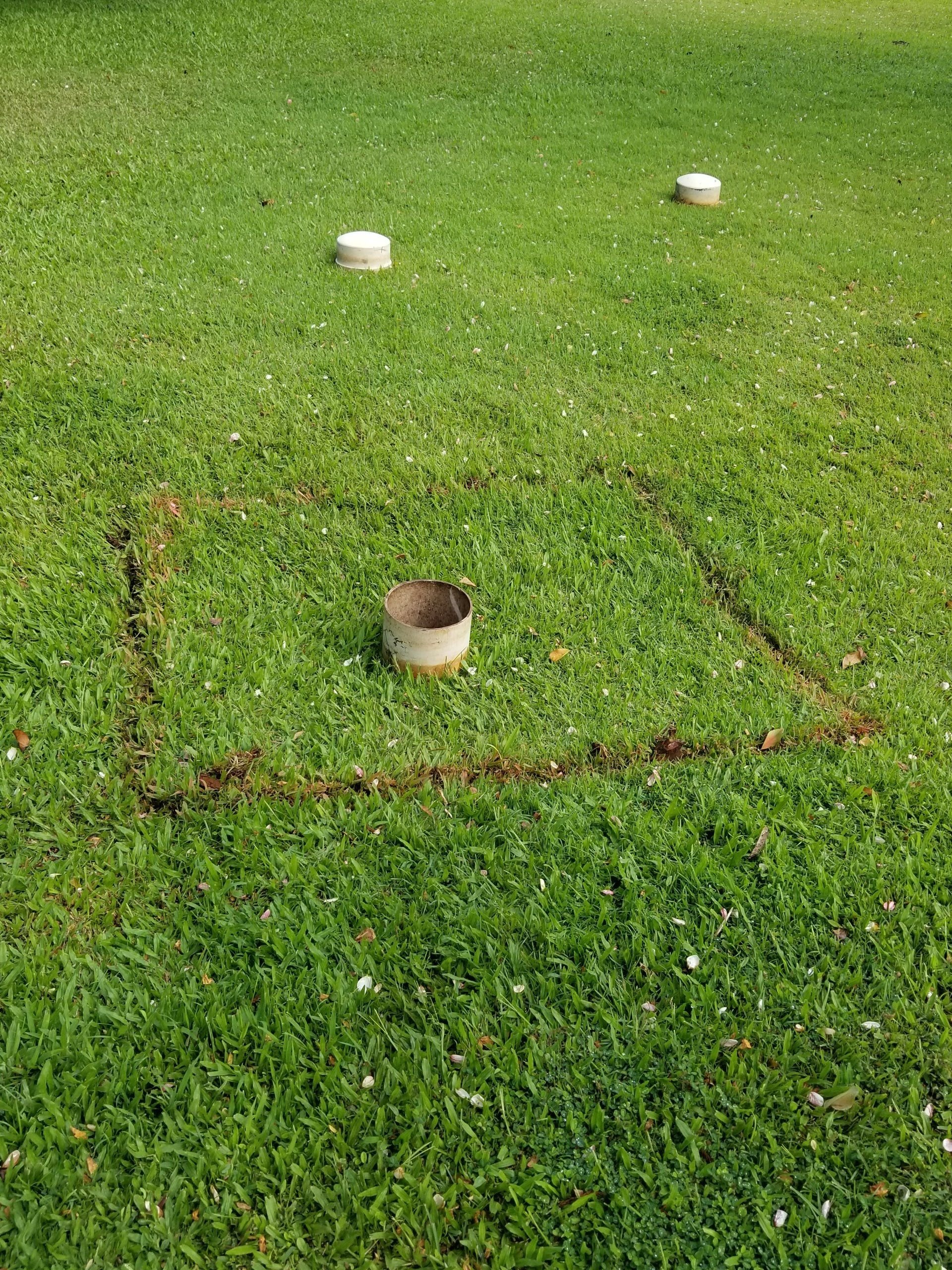 Uncovered lawn access with capped risers nearby.