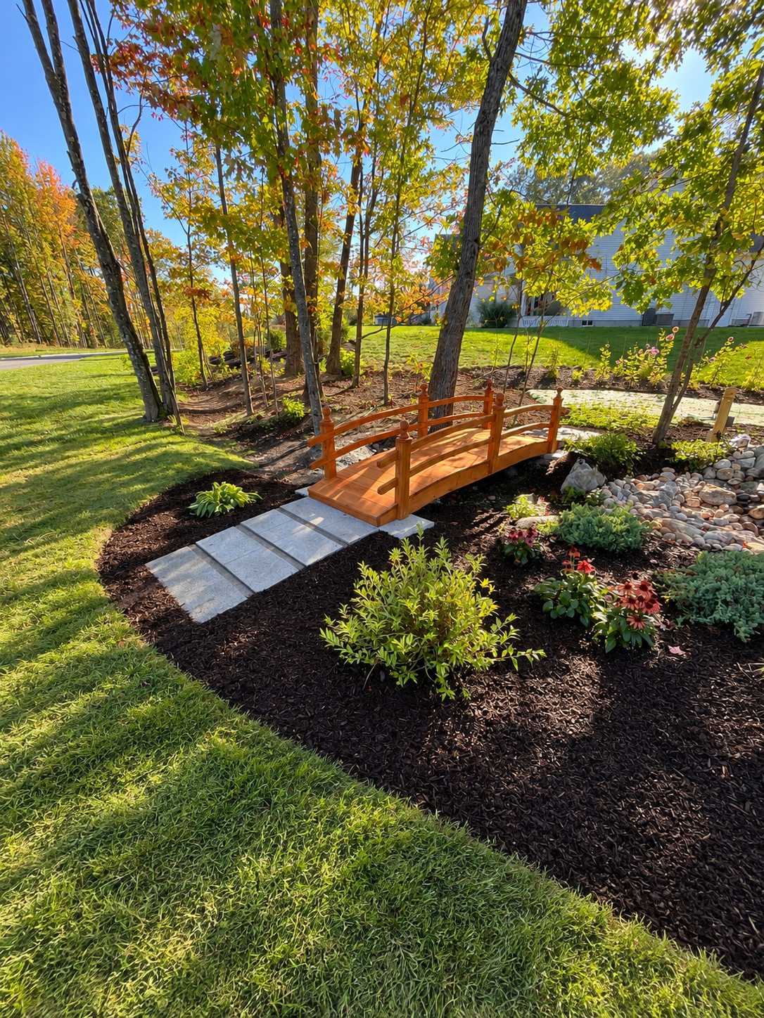 Mulch in a landscaped garden with various plants and flowers. Granite steps.