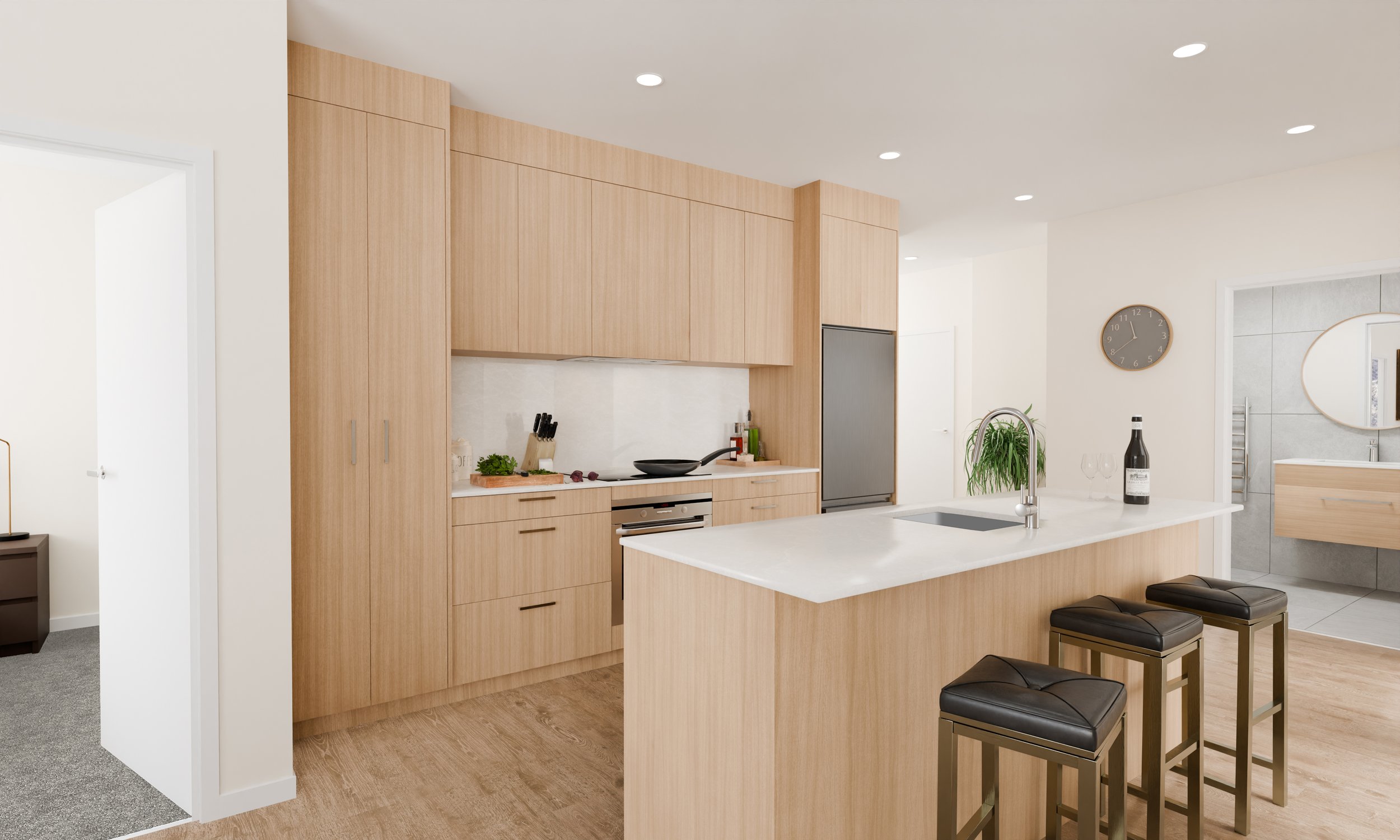 Modern kitchen with light wood cabinets, white countertop island, and bar stools. Decor includes plants, wine bottle, clock, and utensils.