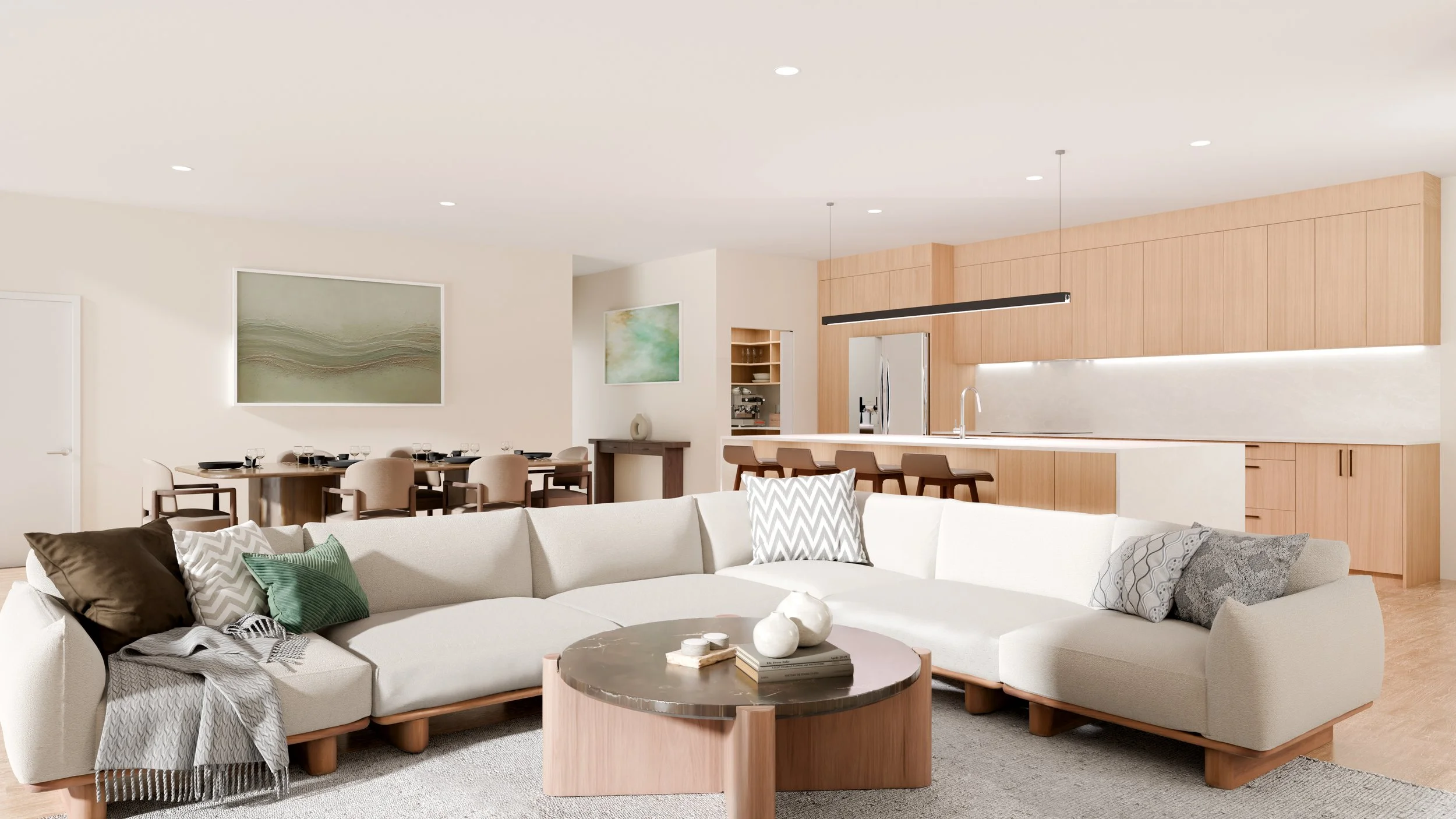 Open-concept living room and kitchen with white sectional sofa, pillows, round coffee table, dining table with chairs, wooden cabinetry, stainless steel refrigerator, pendant lights, and modern artwork on walls.
