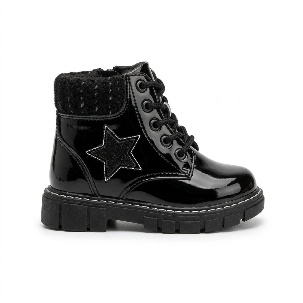 Black patent leather ankle boot with star detail, faux-fur lining, laces, and chunky lug sole