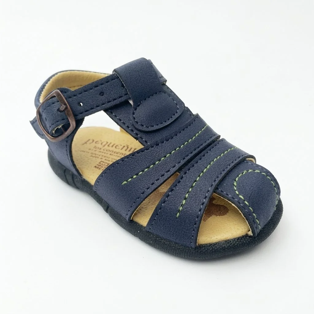 Navy blue children's sandal with adjustable buckle strap, green stitching, and open toe