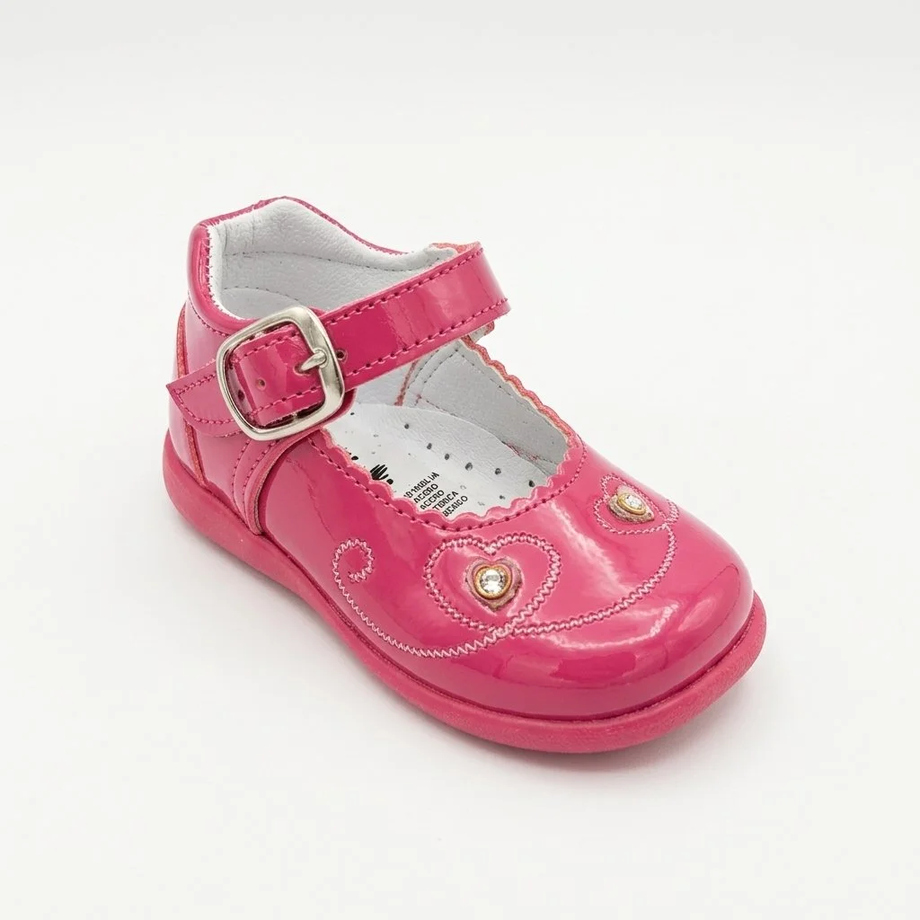 Pink patent leather girls' Mary Jane shoe with ankle buckle, heart-shaped rhinestone embellishments, and floral stitching