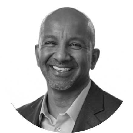 Black man in a suit smiling, black and white photograph.