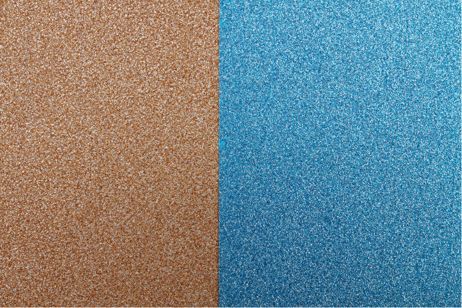 Close-up image of textured spray-painted, almost glittery, surfaces, with one side brown and the other blue.