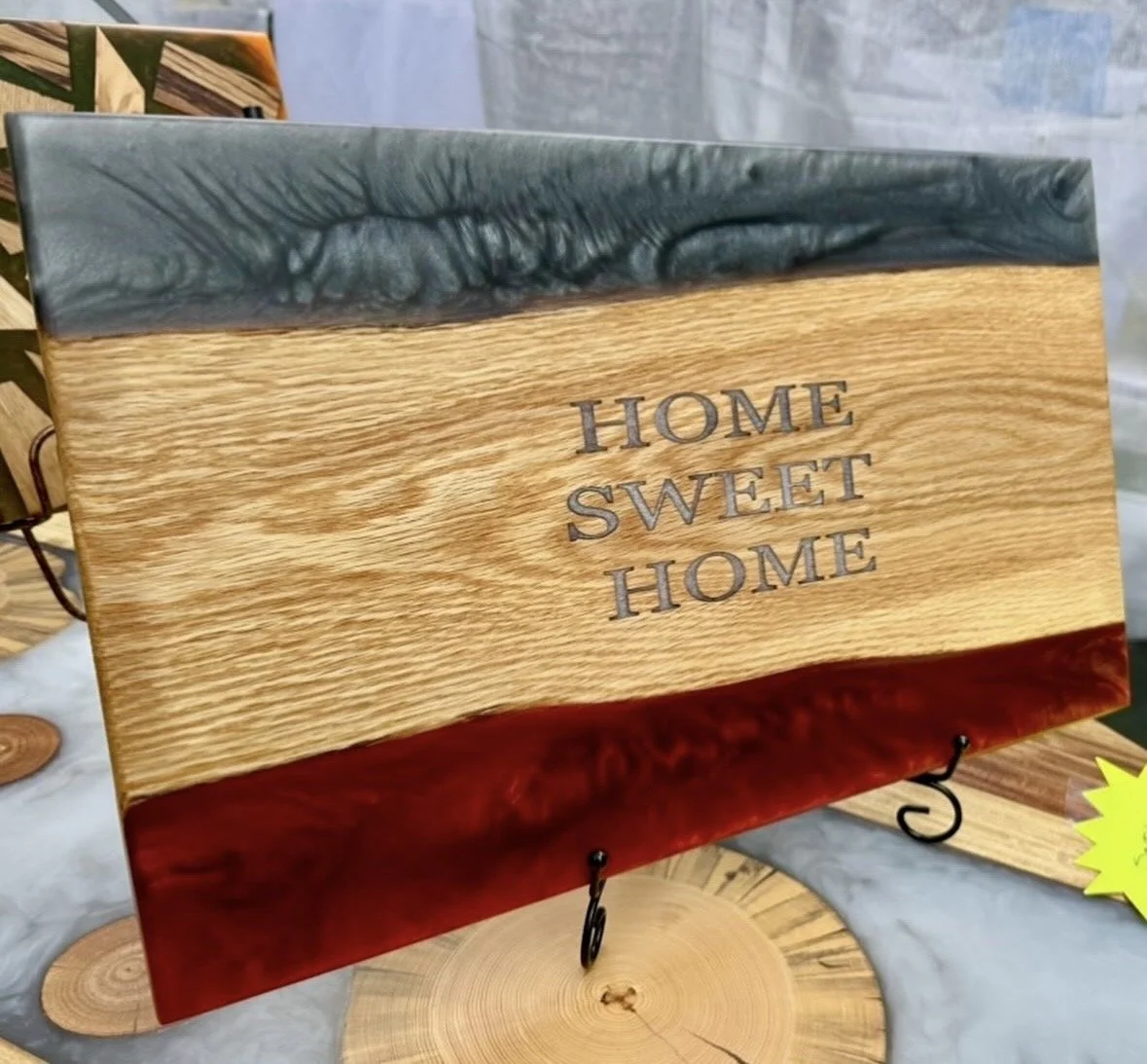 Wooden board with gray and red epoxy accents and the engraved phrase "Home Sweet Home."