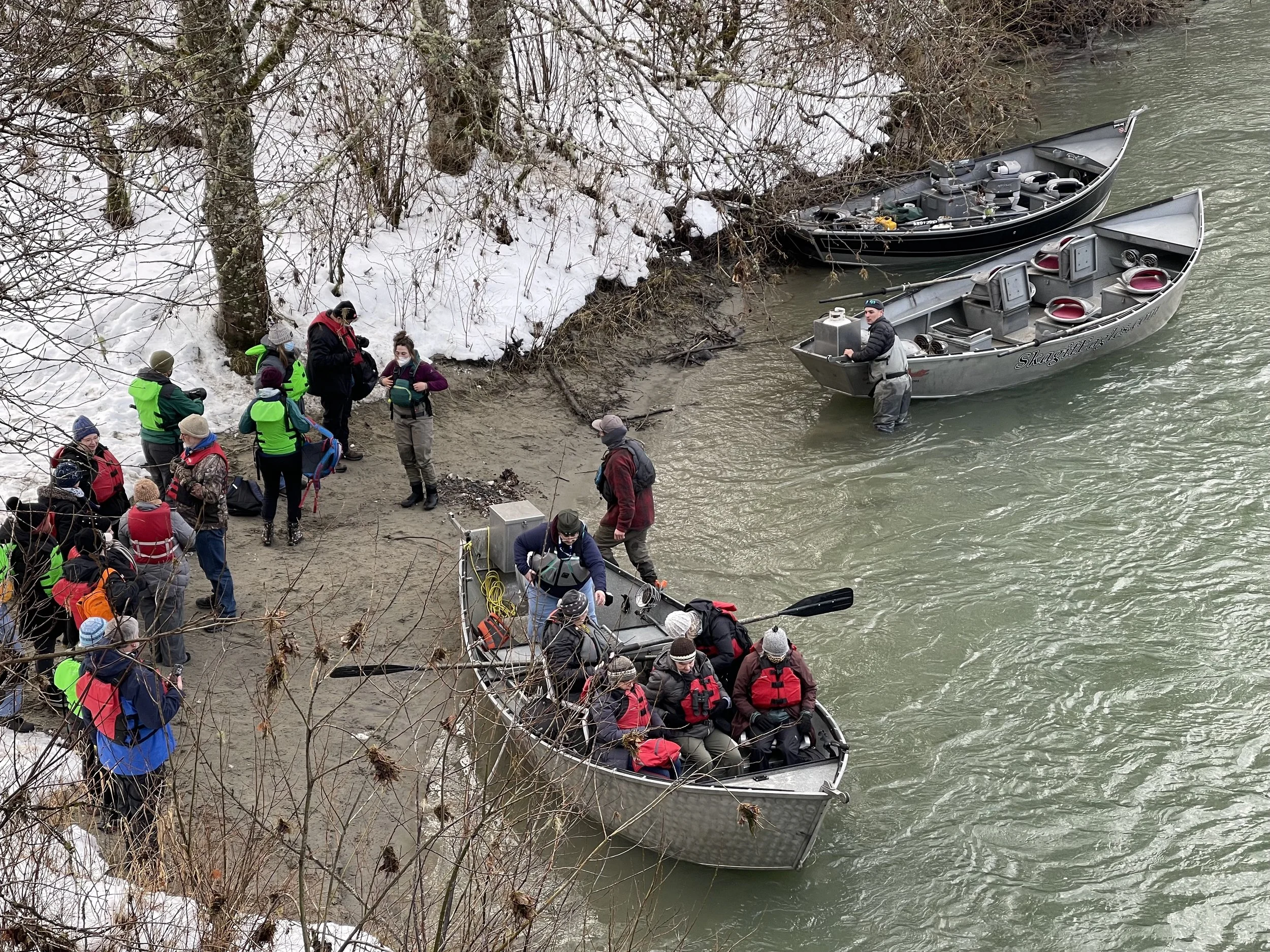 Groups of people preparing to go on the river in boats.