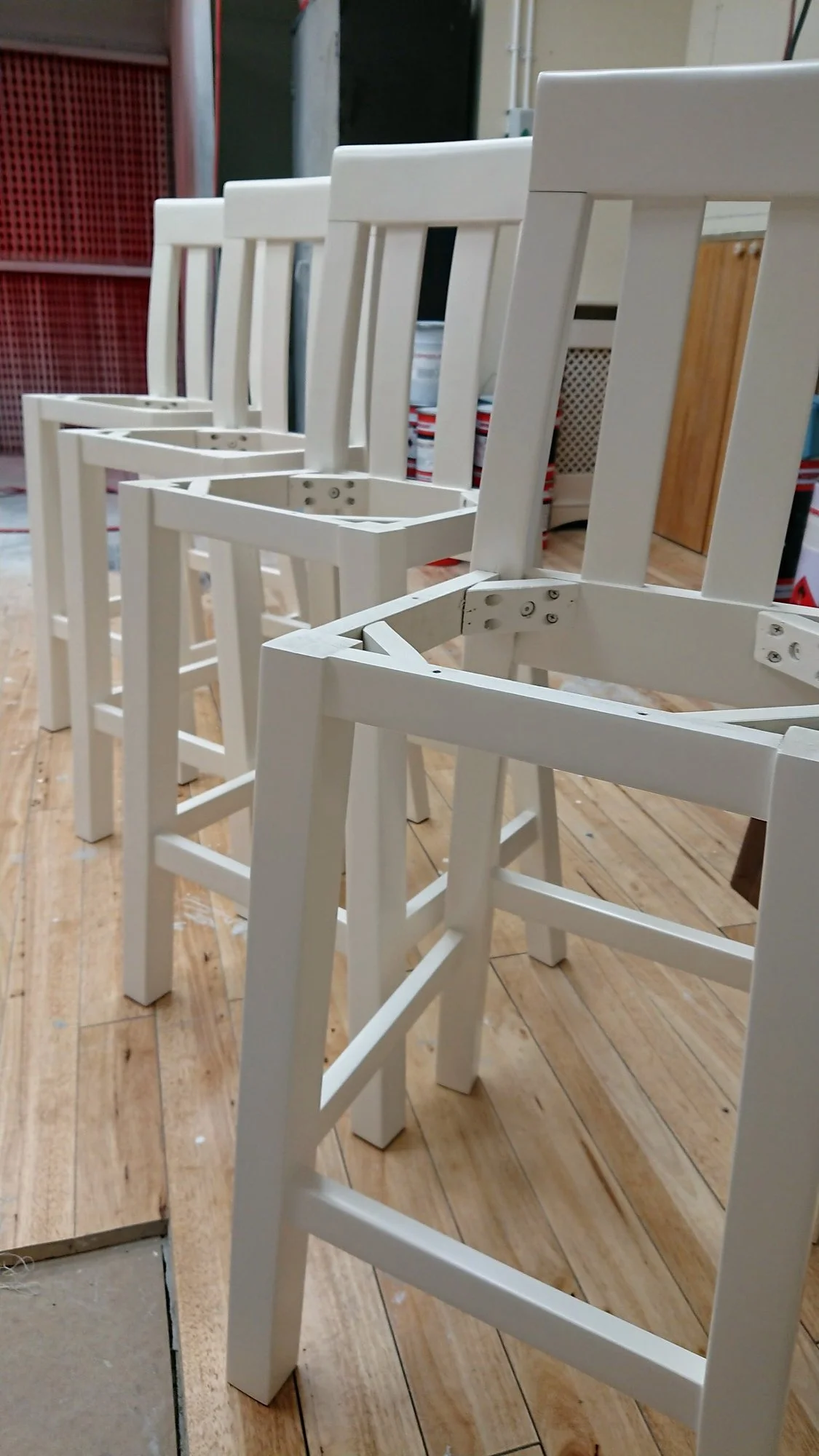 Row of high stools with frames sprayed in cream