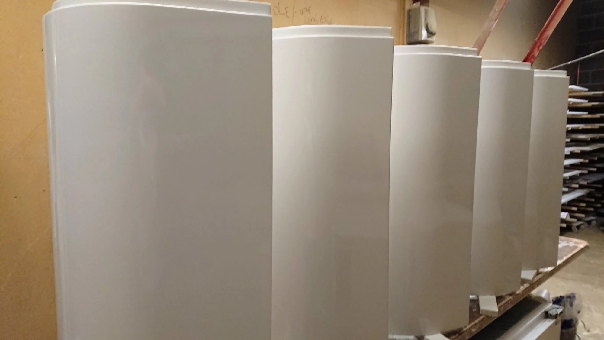 Row of curved white sprayed panels with a smooth finish