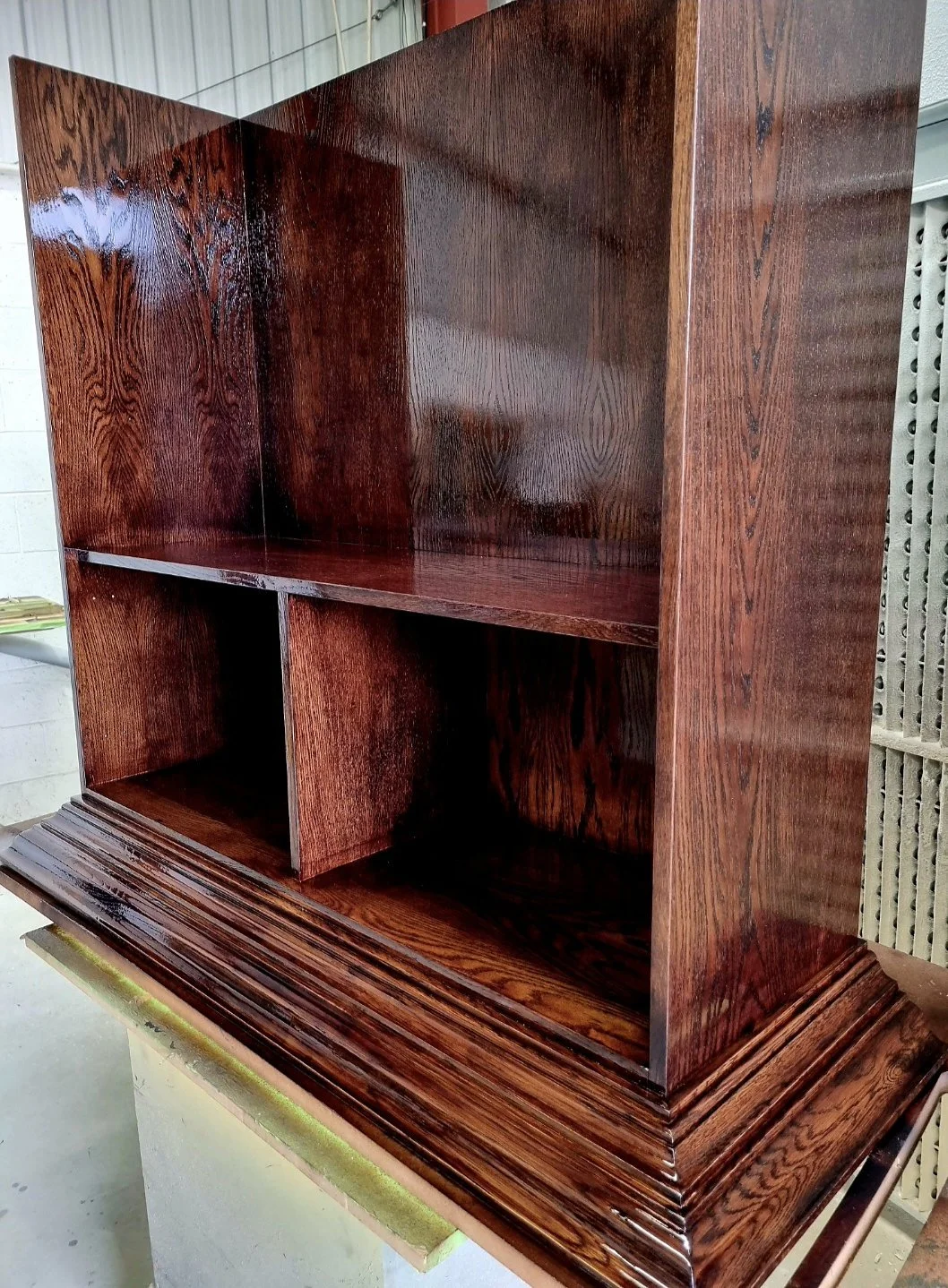 Stained timber bookcase with a high-gloss sprayed finish