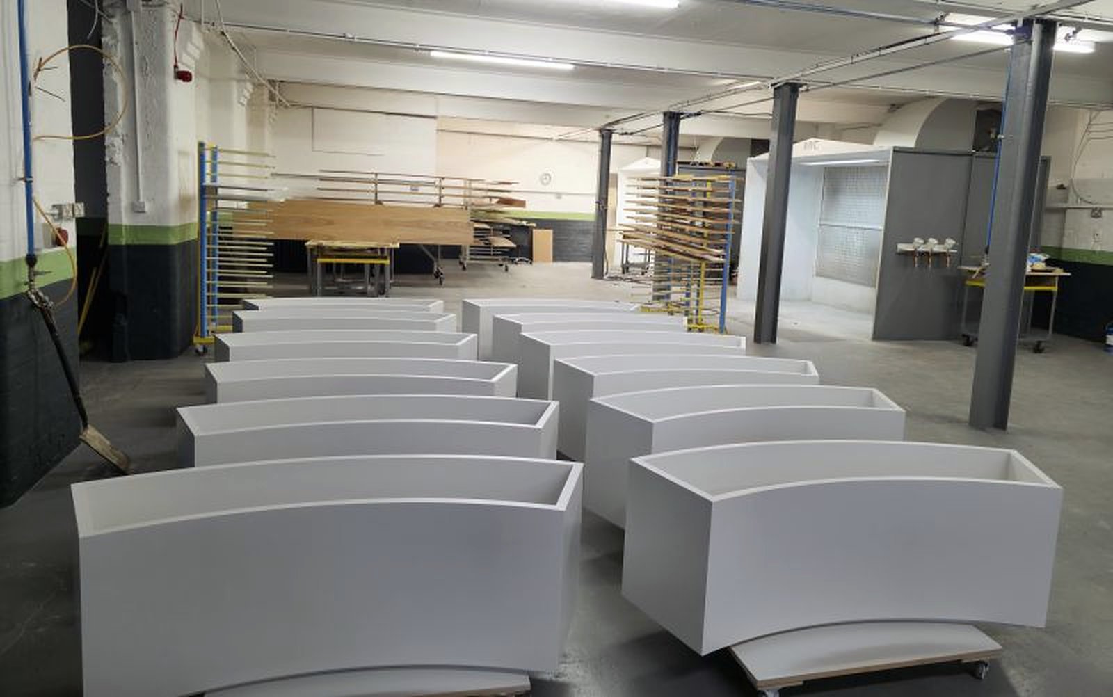 Group of curved white sprayed planters in the workshop
