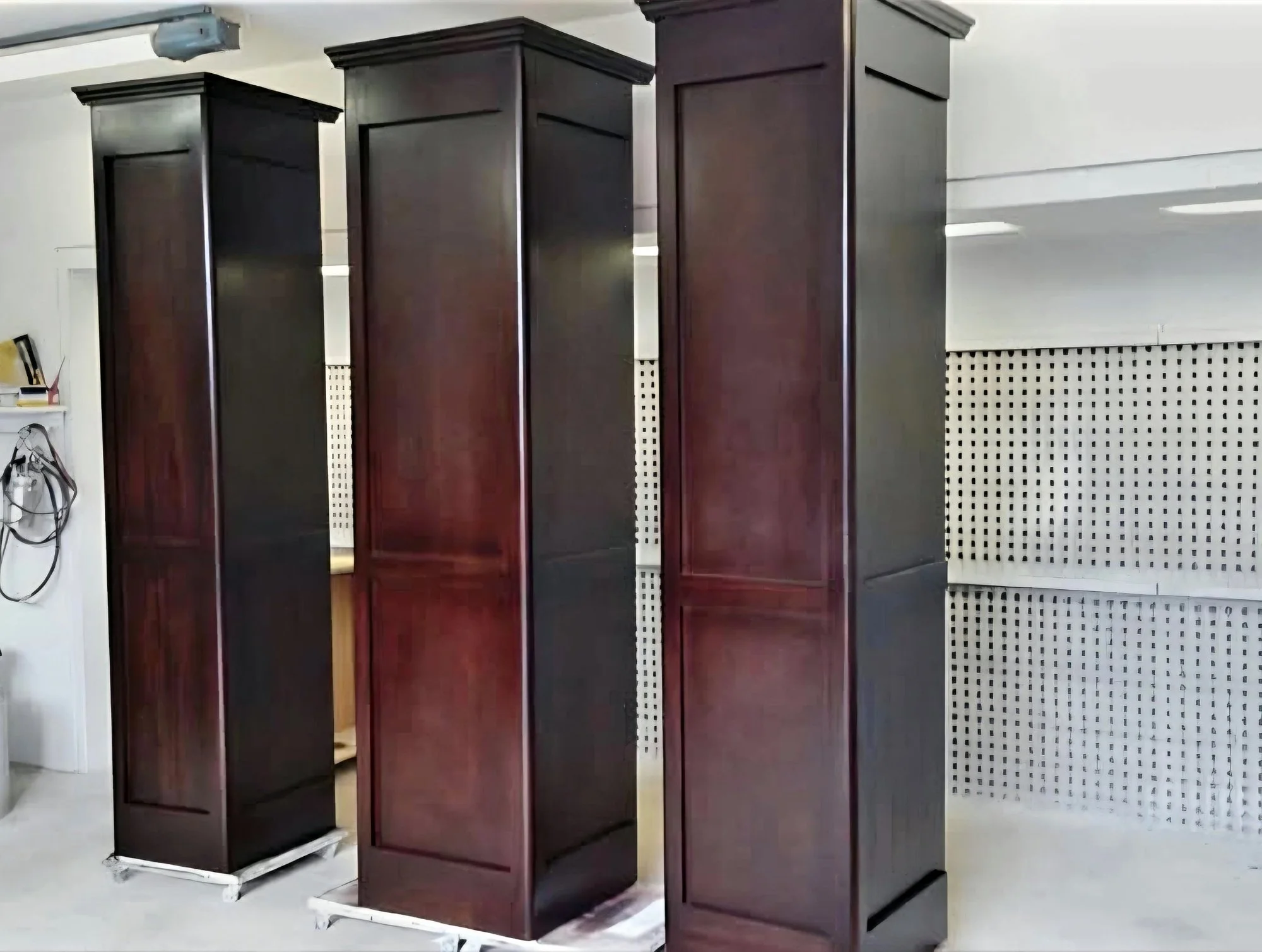 Three tall panelled units with a dark red-brown finish