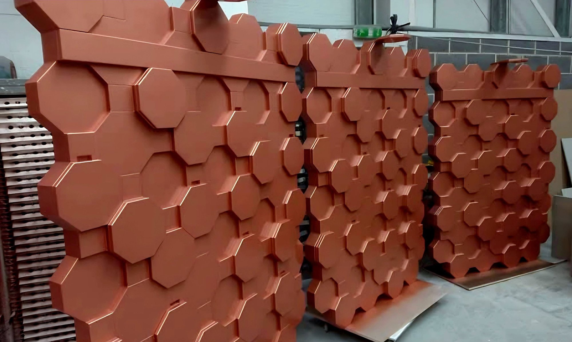 Three sprayed copper-coloured wall panels with a raised octagon pattern