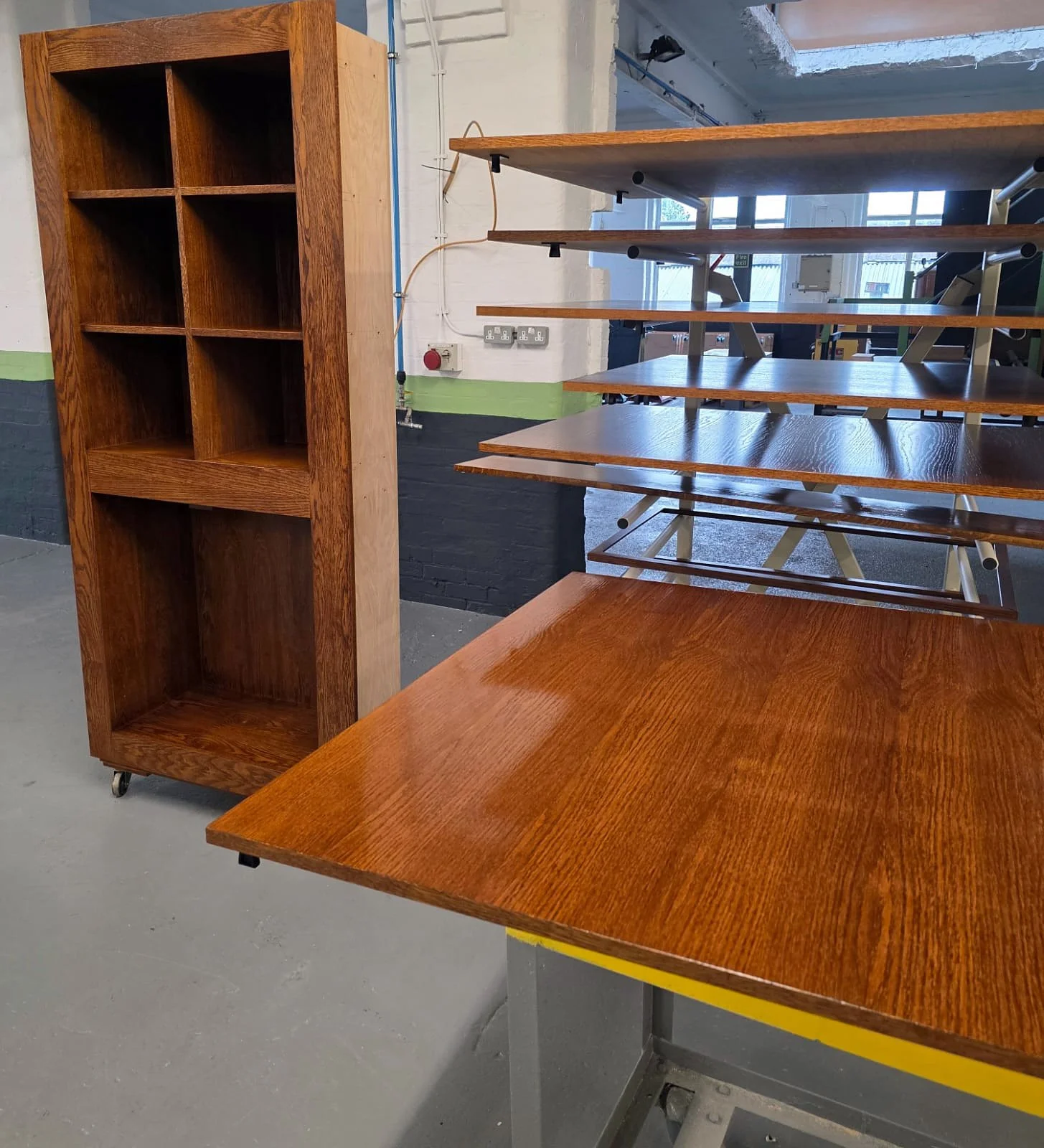 Stained timber bookcase and tabletops on drying racks