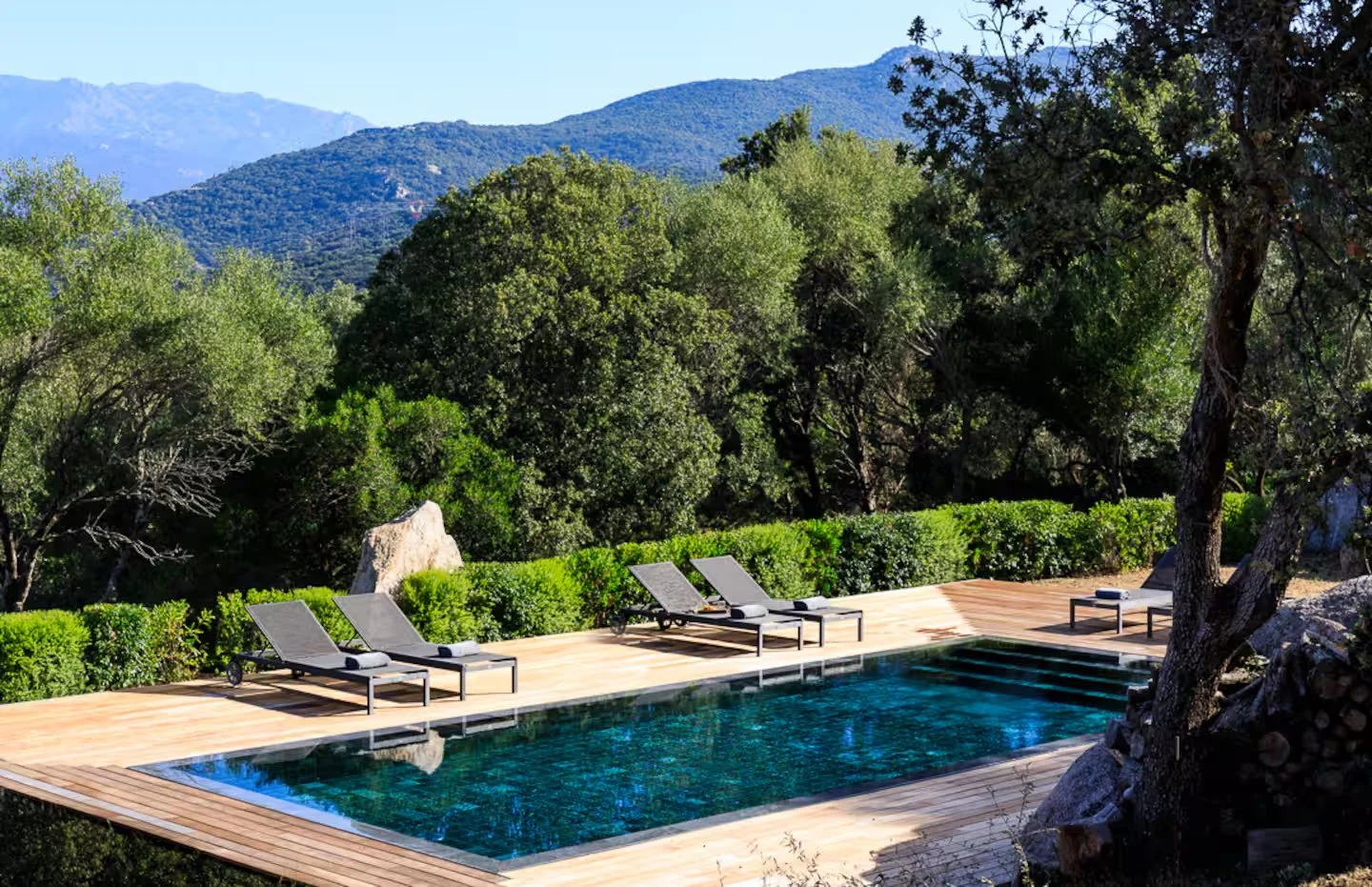 Piscine de la Villa Occhinello avec terrasse en bois et vue sur les montagnes du Valinco.
