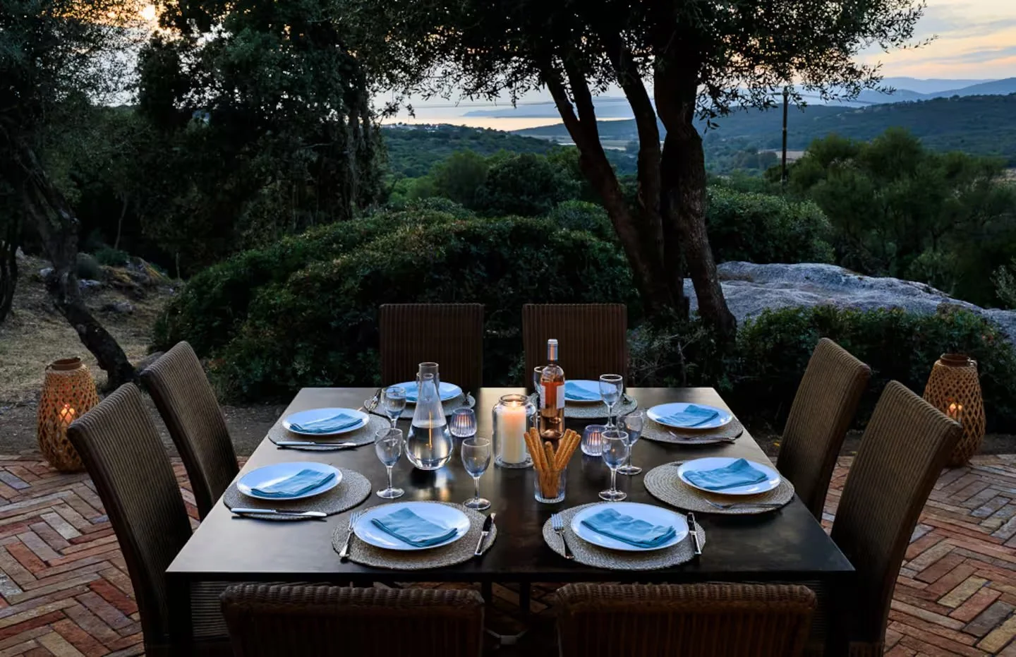 Table dressée en extérieur à la villa Occhinello, face au coucher du soleil.