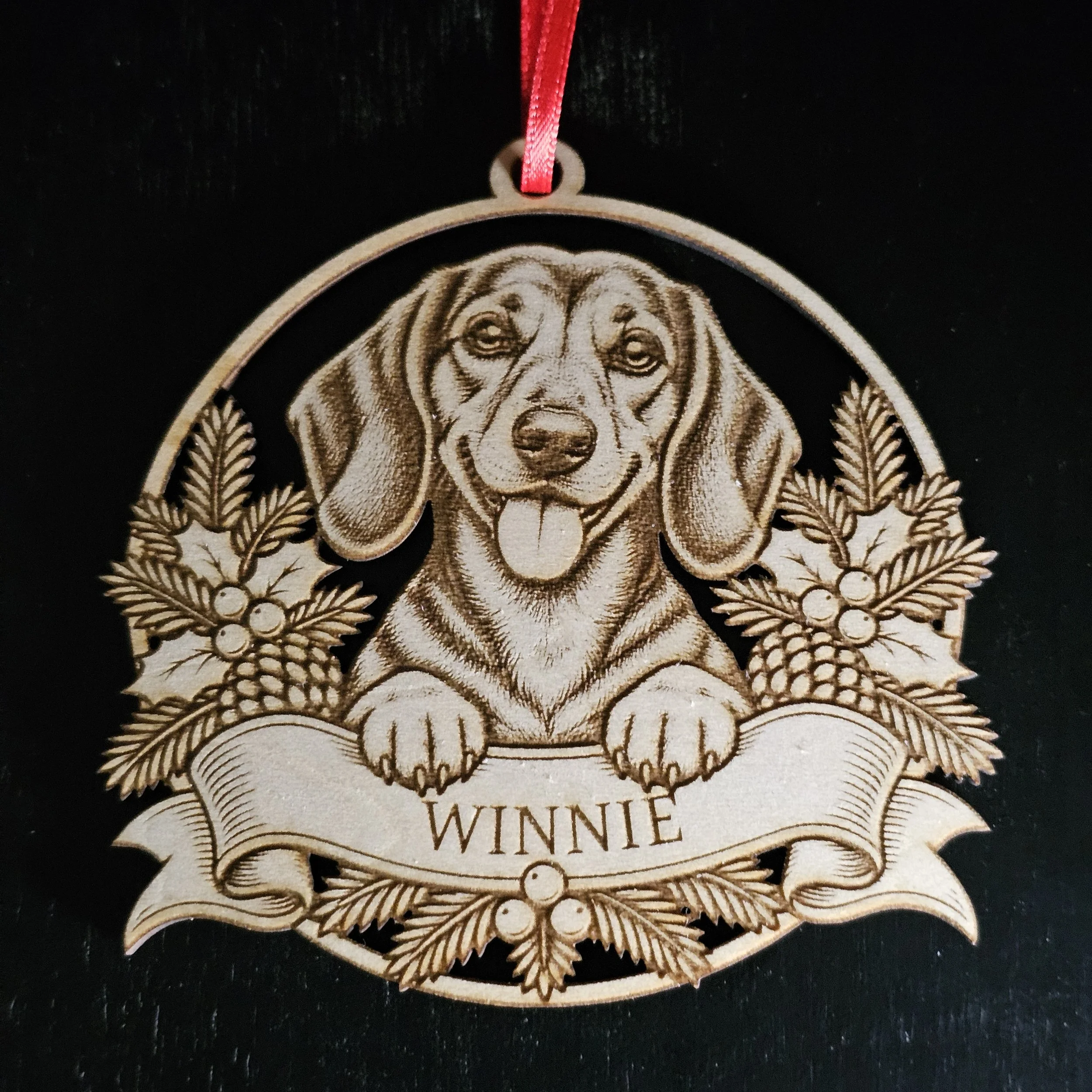 Dachshund ornament with name detail against solid black background.