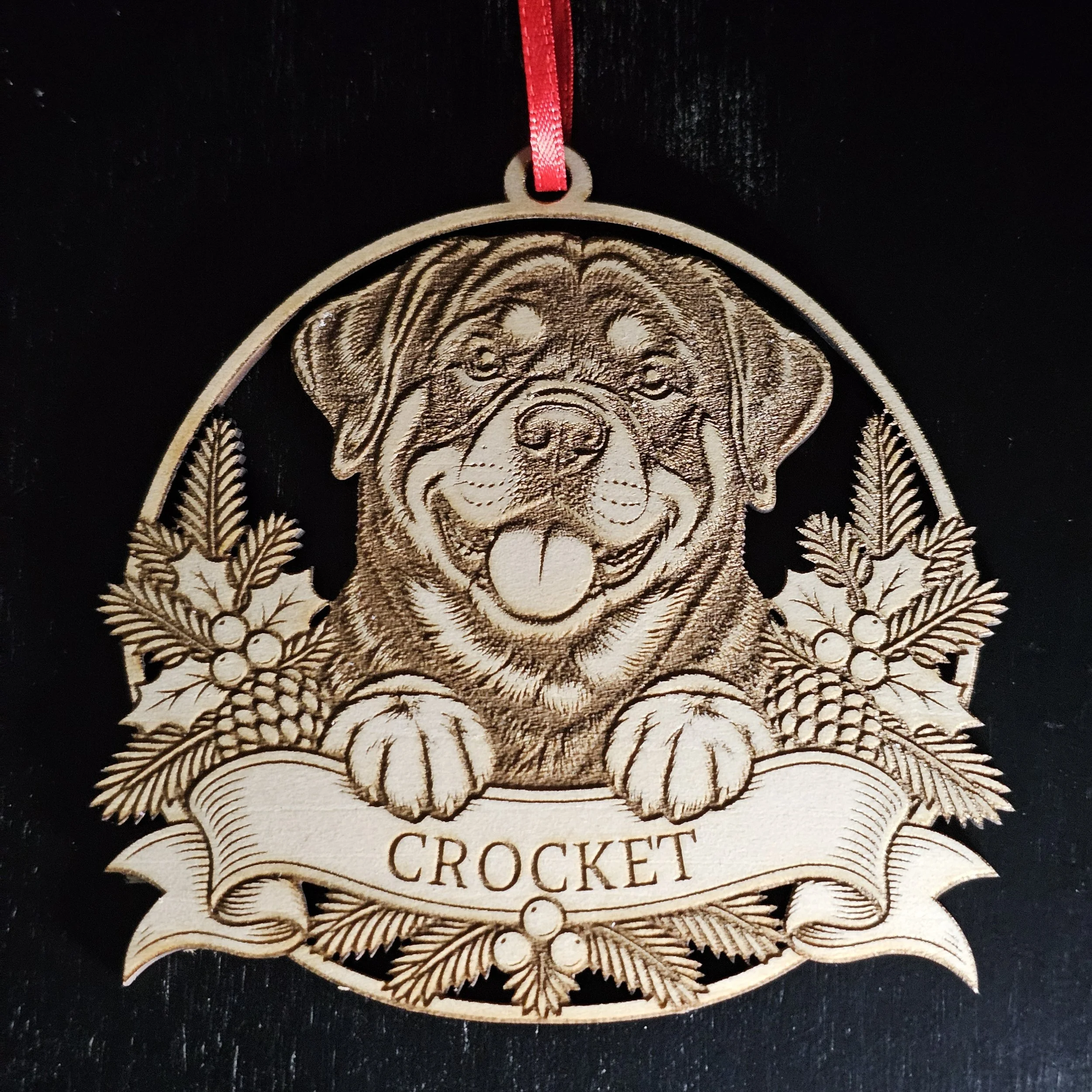 Rottweiler ornament with name detail against solid black background.