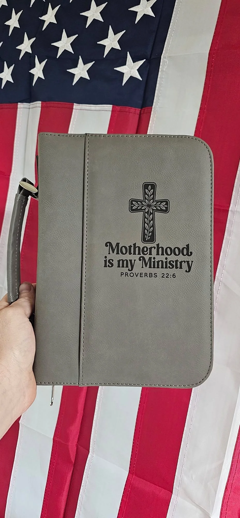 Motherhood is My Ministry Engraved Bible Cover in front of American Flag