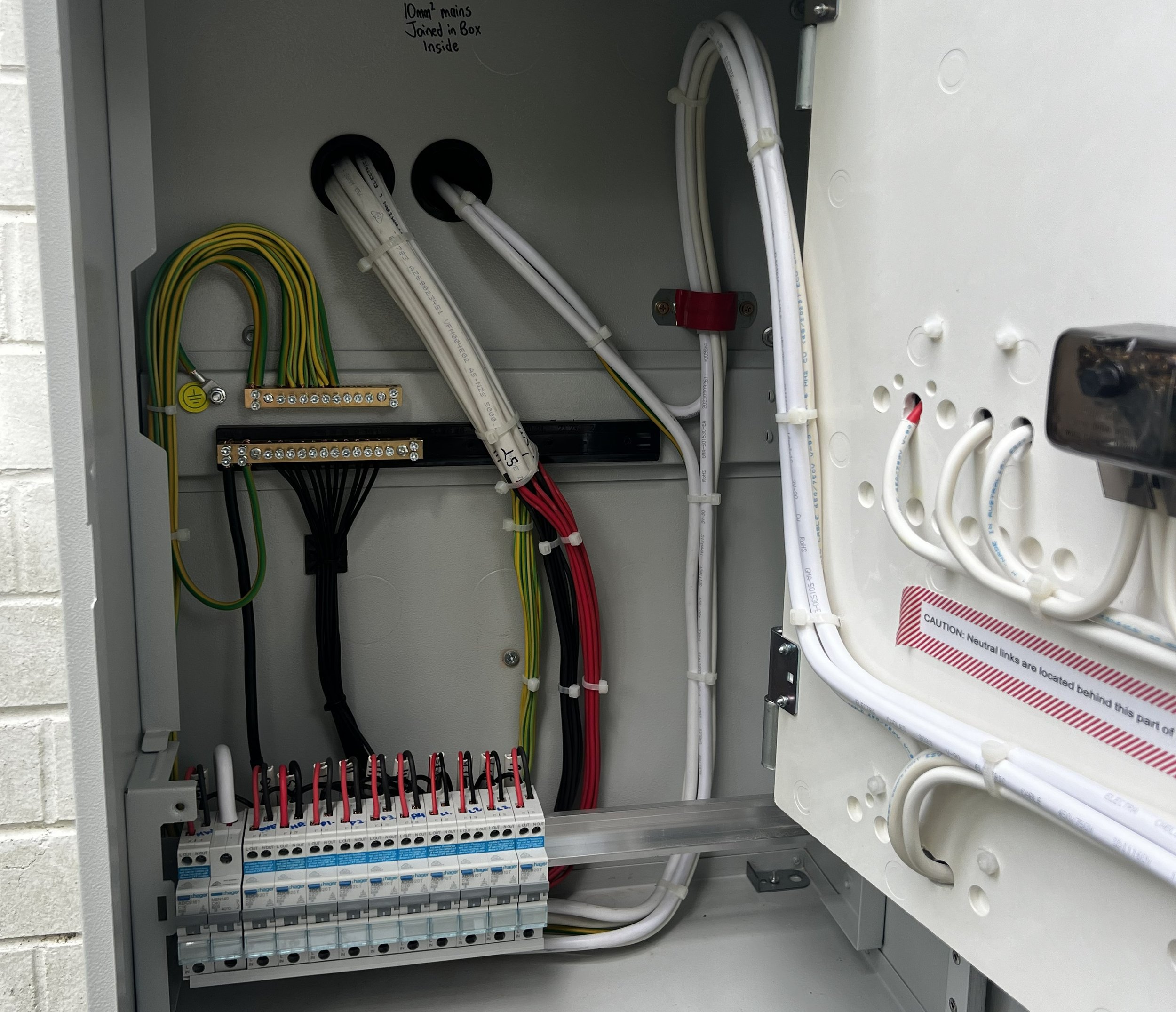 Electrical panel with organized wires, circuit breakers, and labels inside.