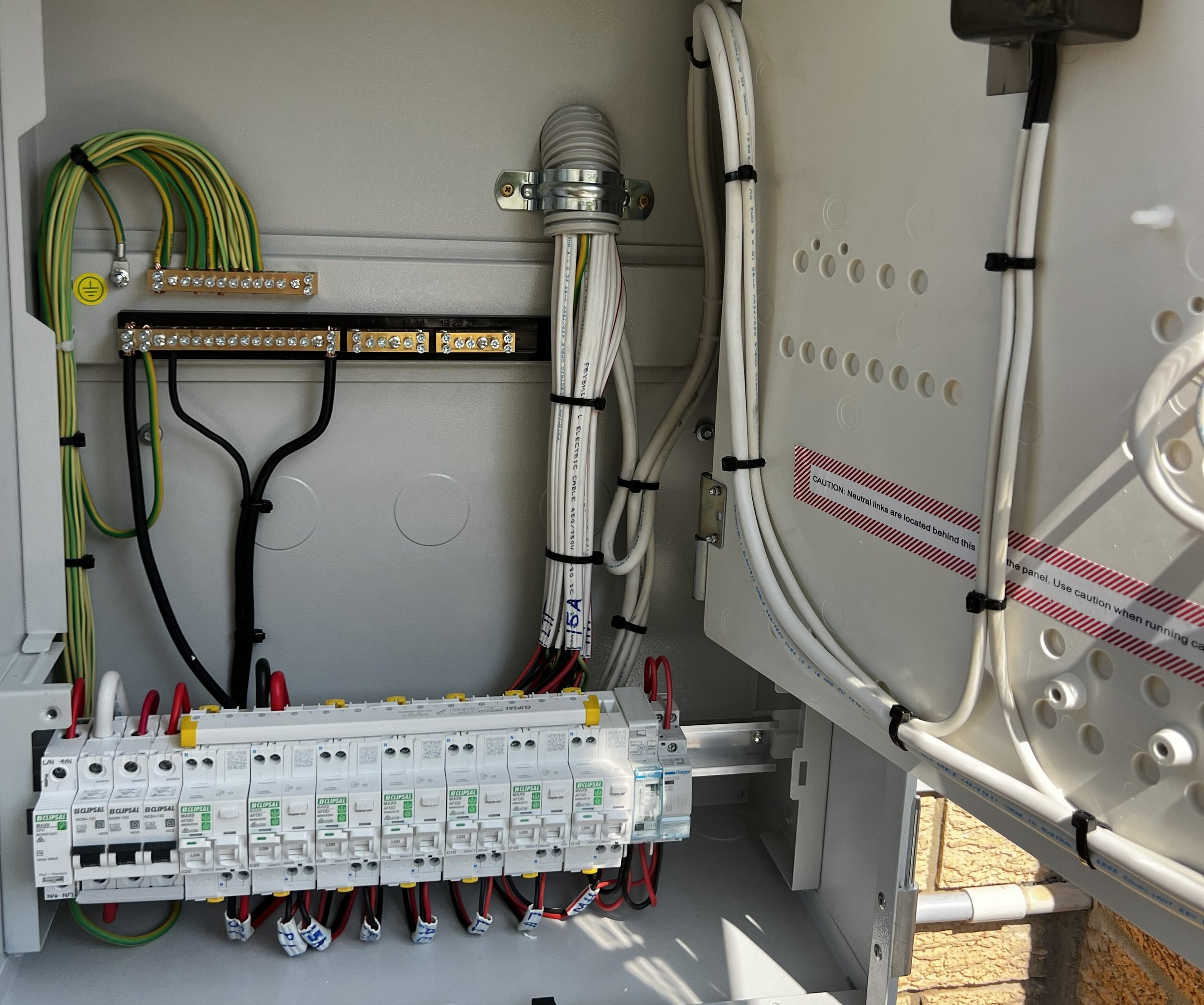 Electrical control panel with various wires, circuit breakers, and terminal blocks.