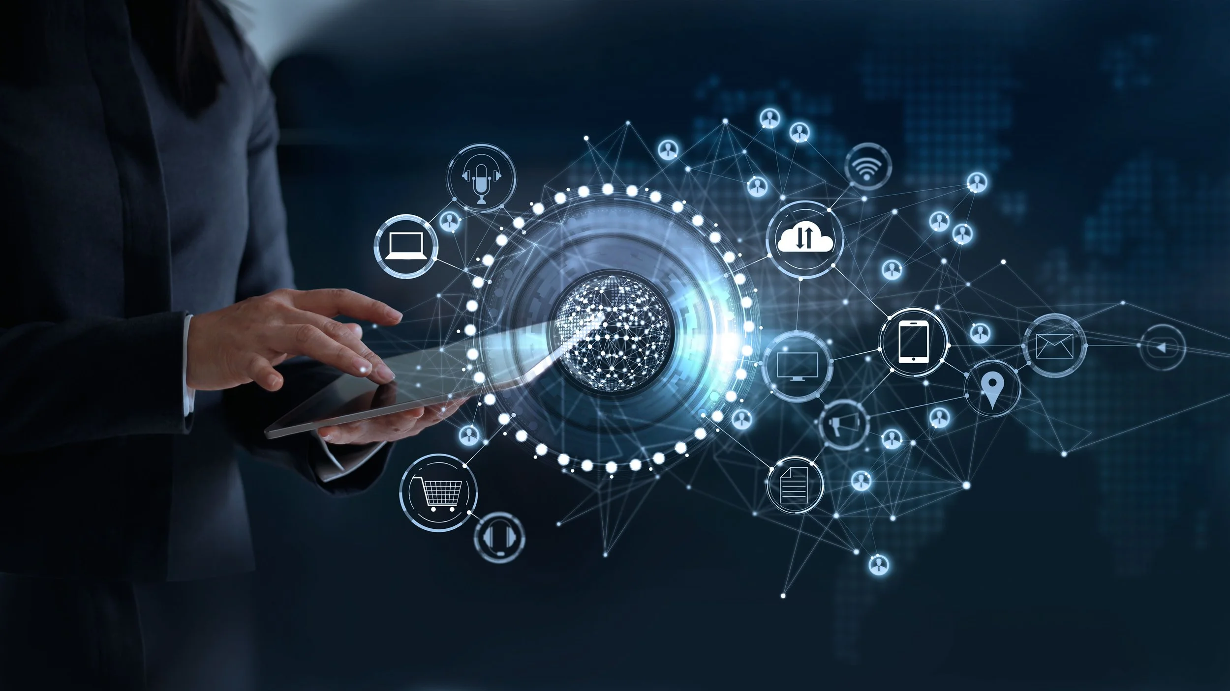 A person in a business suit holding a tablet with a digital interface of interconnected icons representing cloud computing, Wi-Fi, mobile devices, shopping cart, location, and communication symbols, illustrating digital technology and networking concepts.